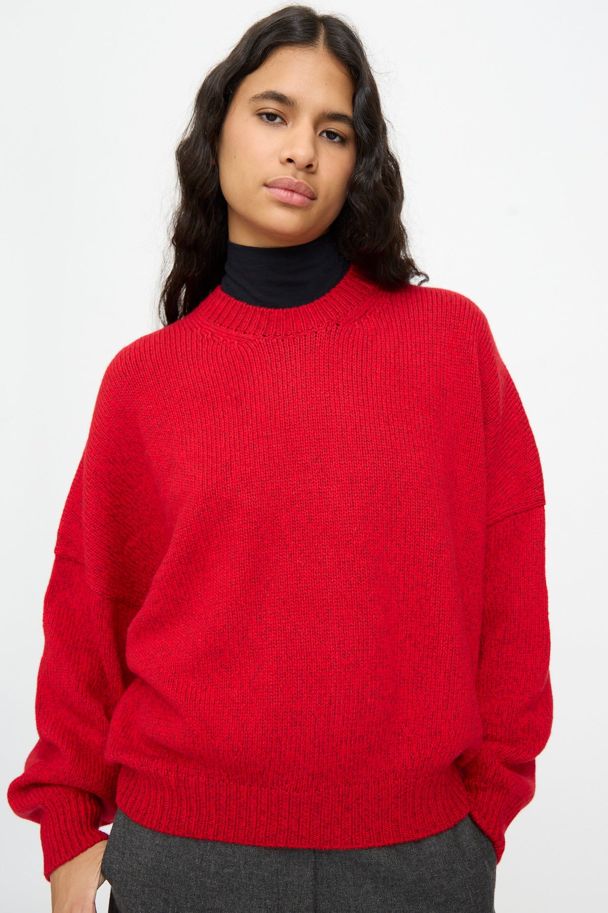 Person wearing a Cordera Merino and Cashmere Sweater in Red over a black turtleneck.