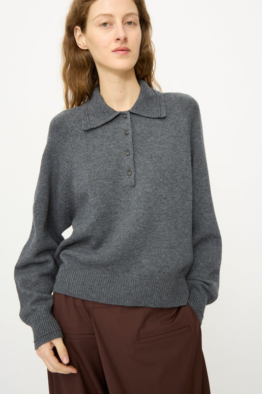 A person wears the Cordera Merino Wool Polo Sweater in Grey with brown pants, standing against a plain white background.
