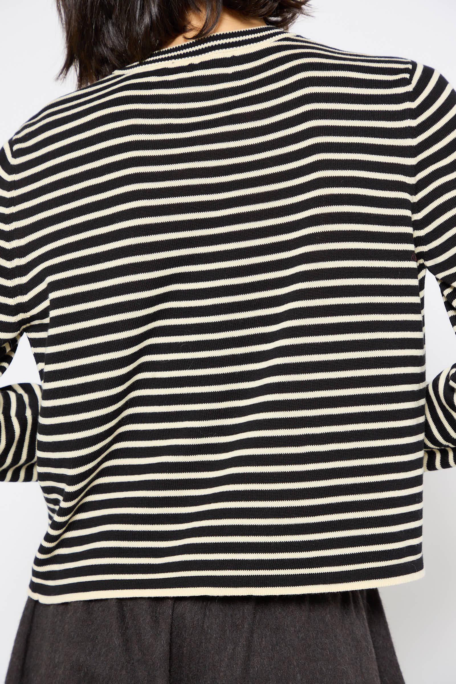 Back view of a person wearing a relaxed fit, black and white Organic Cotton T-Shirt in Striped by Cordera.