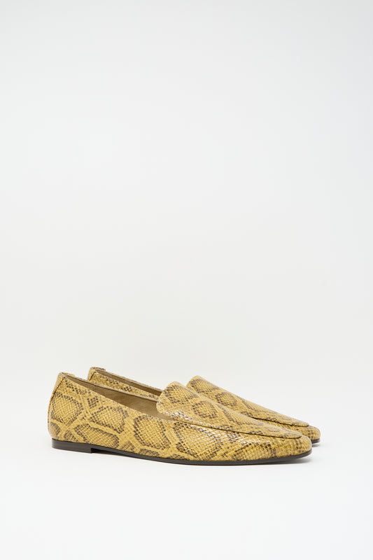 Cordera Pointy Loafer in Snake featuring pointy-toe loafers in snake-embossed leather with a yellow and brown pattern and low heels.