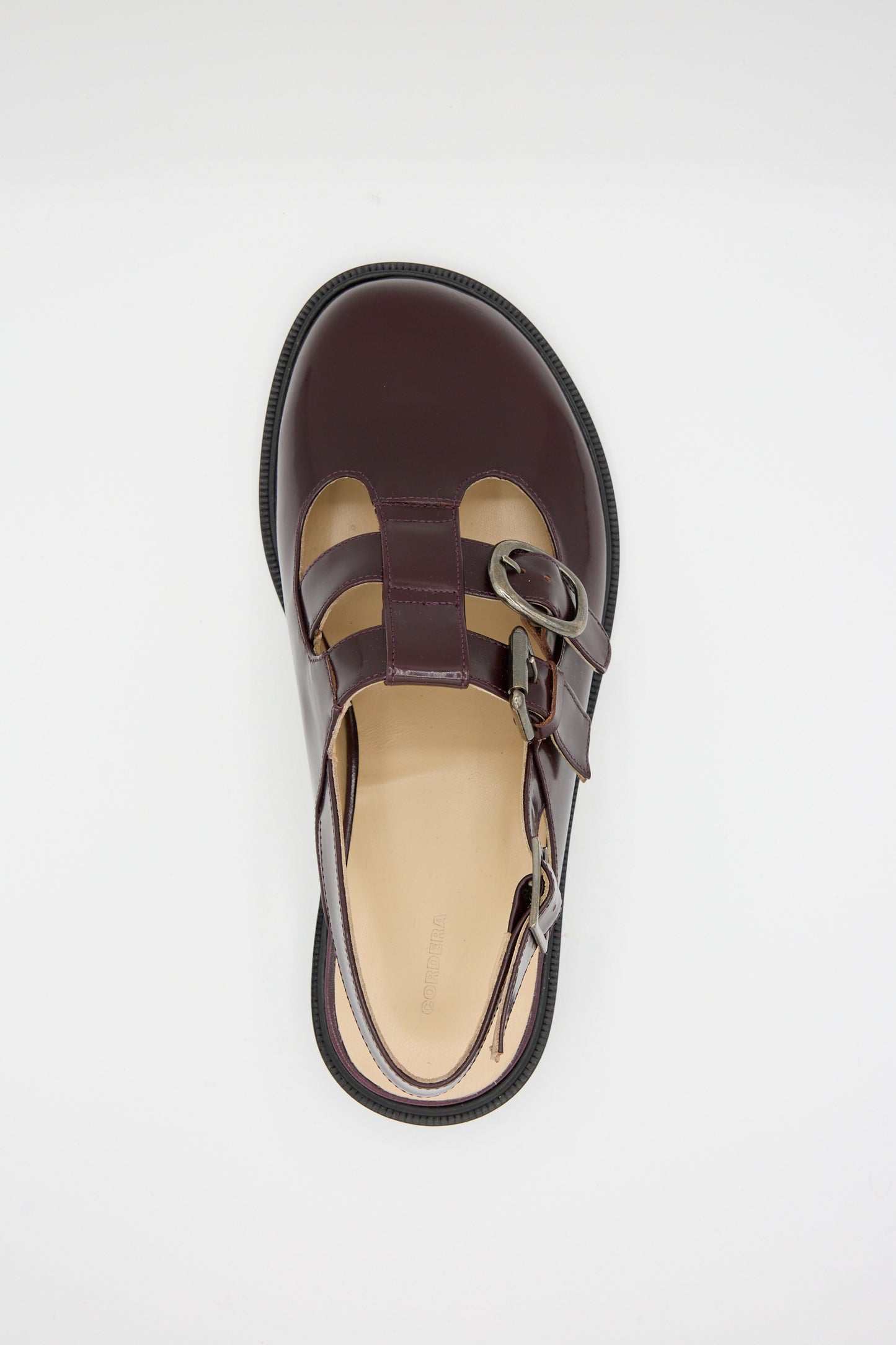 The aerial view shows a Cordera Slingback Mary Jane in Burgundy, featuring a single calfskin design with cut-out elements and double buckle closure.