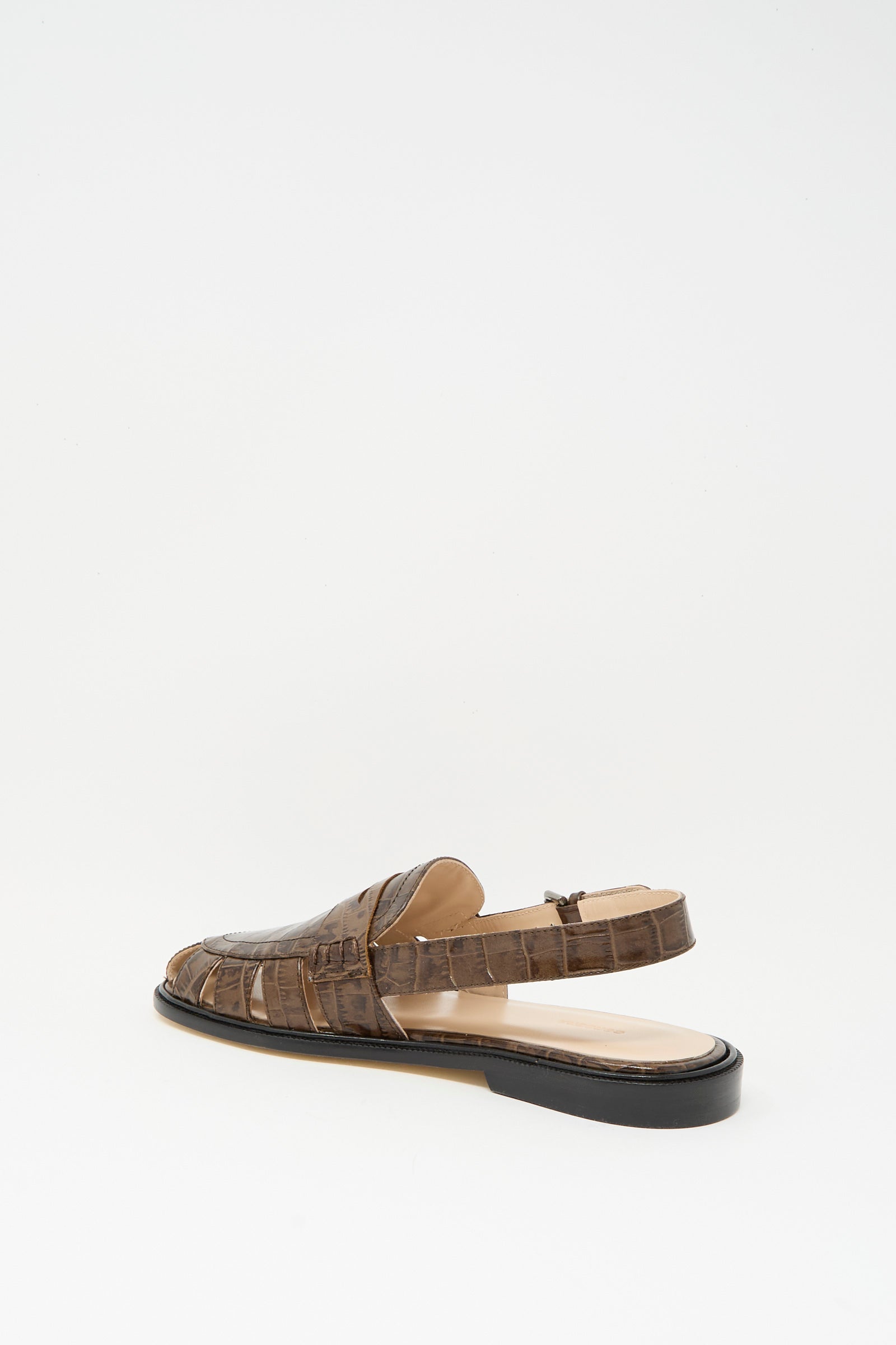 The Slingback Loafer in Crocodile by Cordera features a brown crocodile pattern, closed toe, open back, and low black heel. Expertly crafted in Spain, it’s shown on a plain white background.