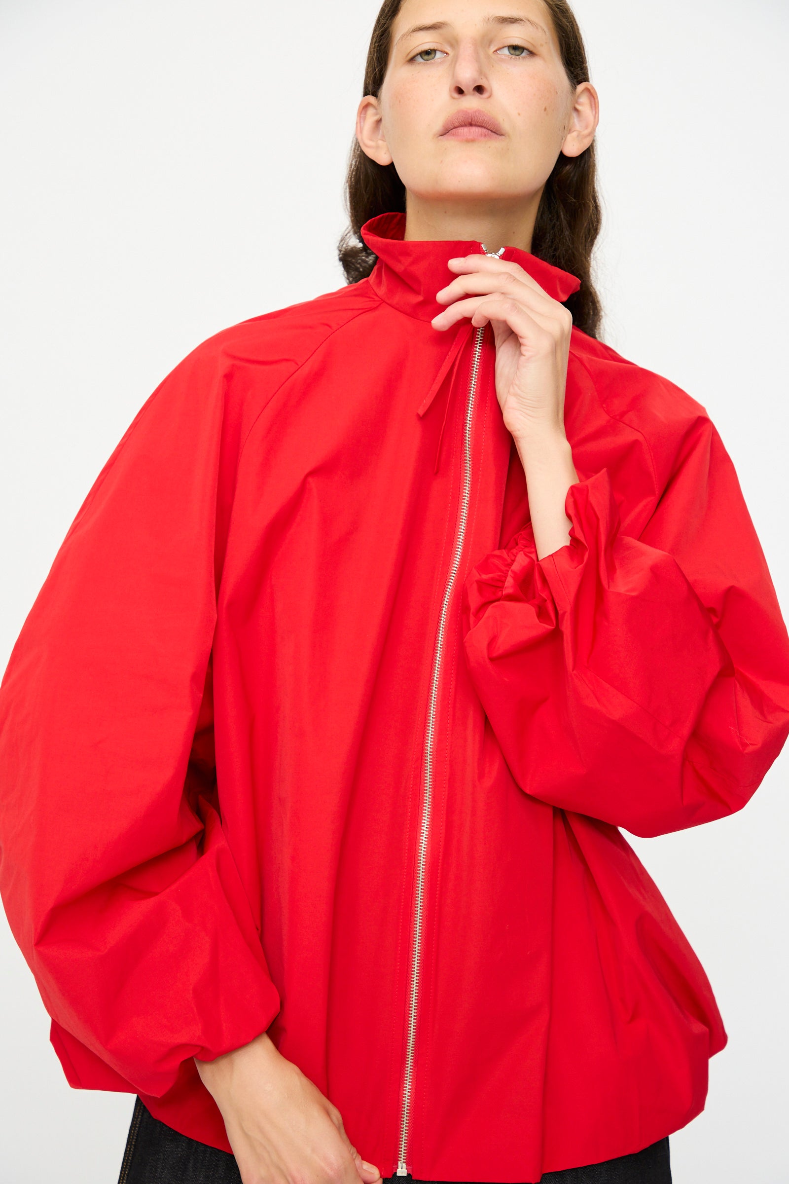 A person wears the Cordera Utility Balloon Jacket in Red, a loose-fitting cotton blend with gathered sleeves, standing against a plain white background.