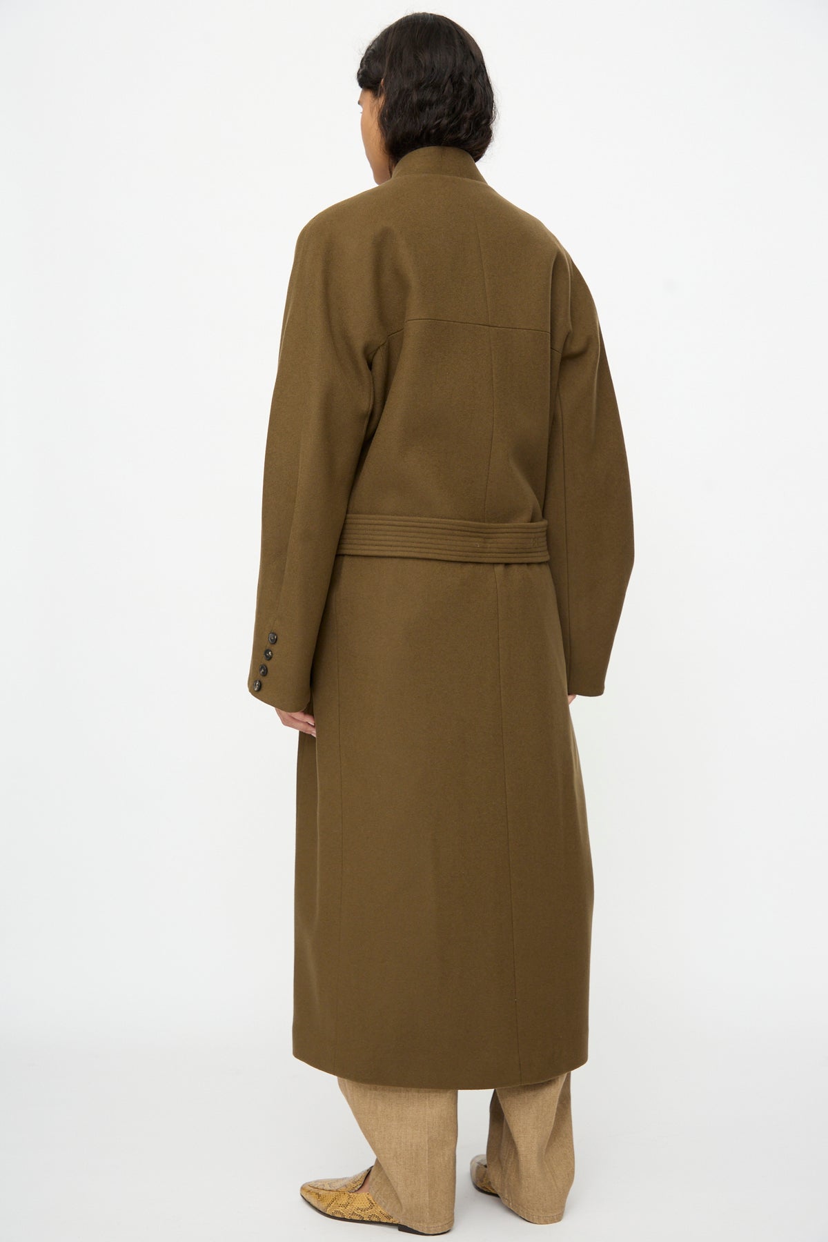 Back view of a person wearing an olive-green oversized Virgin Wool Long Coat in Pardo with a belted waist.