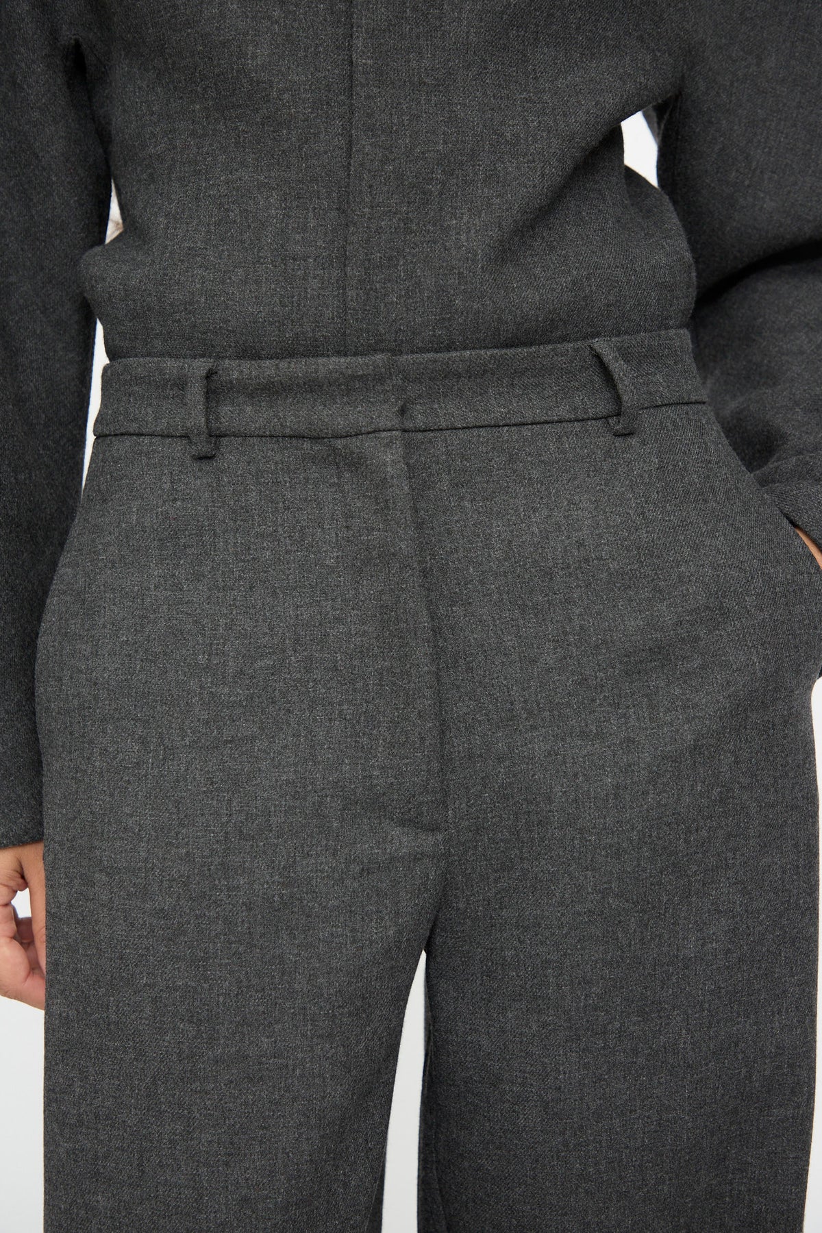Close-up of charcoal grey Wool Curved Pants in Anthracite, a relaxed fit style featuring an adjustable waistband with belt loops and side pockets.