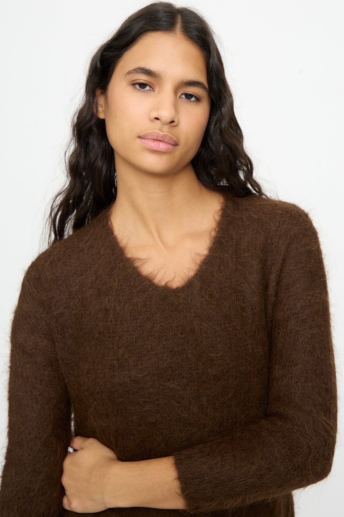 A woman wearing a brown fuzzy Cosmic Wonder Alpaca Knitted Evening Dress featuring a long-sleeved V-neck.