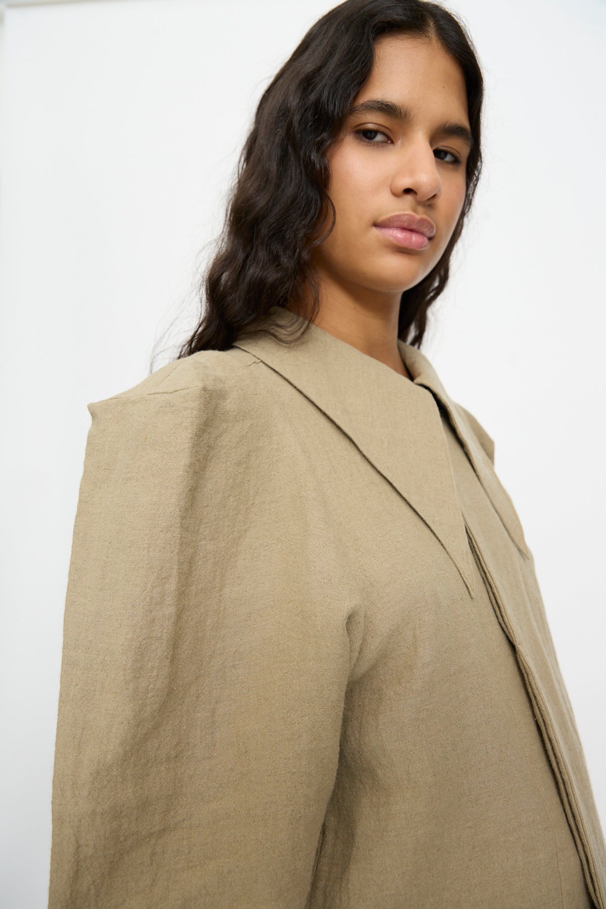 A beige Cosmic Wonder Band Collar Shirt in linen wool with a wide collar, long sleeves, and structured shoulders.