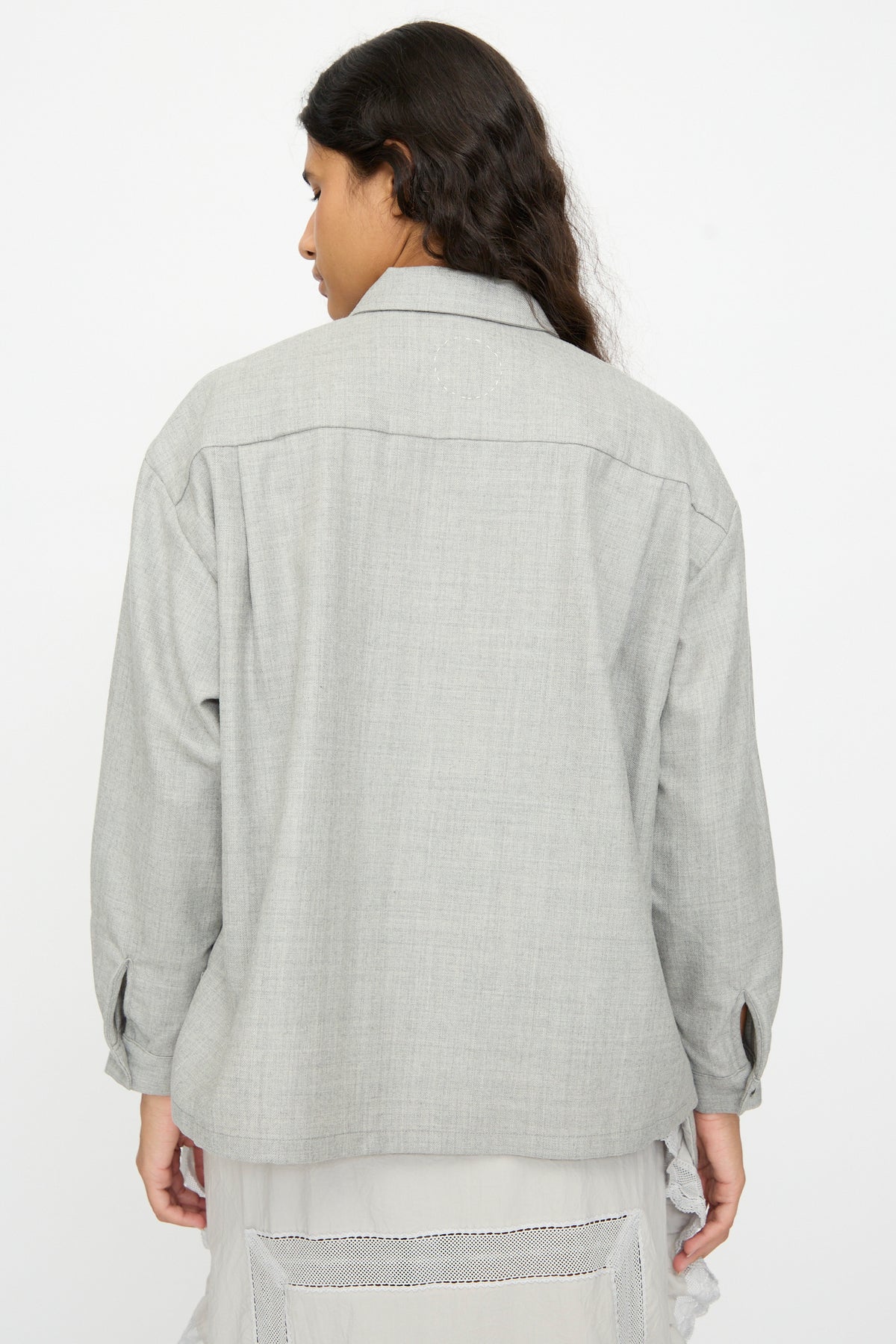 Back view of a person wearing a gray Cosmic Wonder Nostalgic Artist’s Camp Collar Shirt layered over a white garment with a lace trim hem.