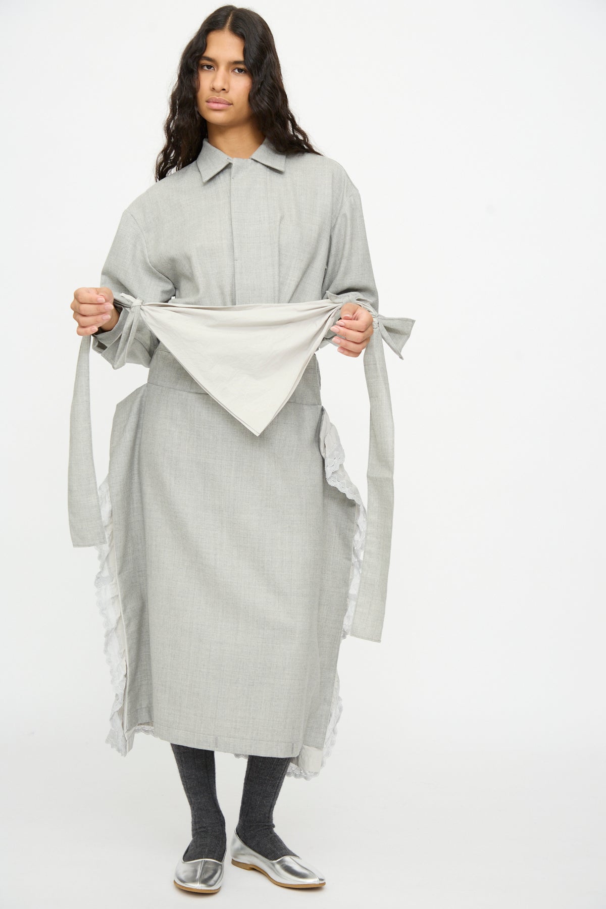 A person in a gray wool and cotton collared shirt and matching long skirt with a Nostalgic Painter’s Star Belt in Gray, gray tights, and metallic silver flats.