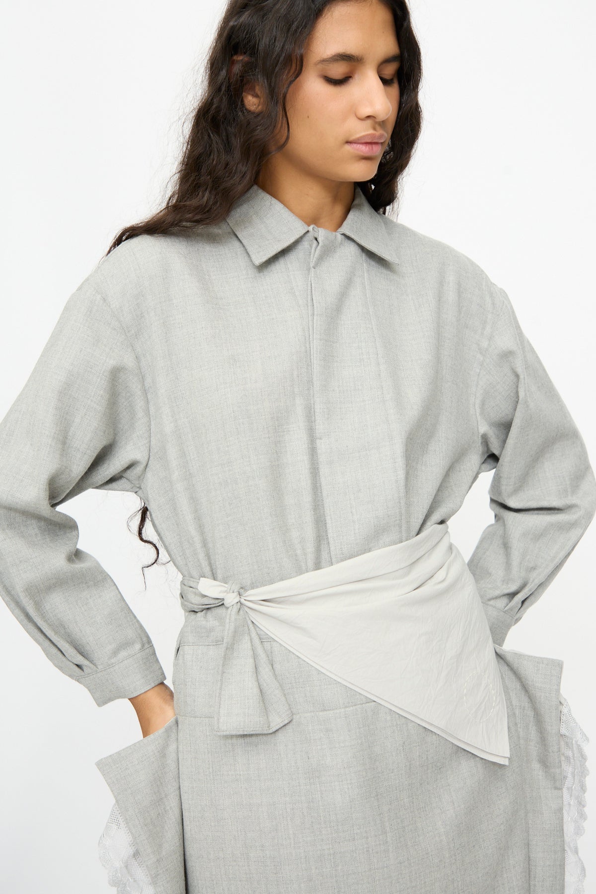 Person wearing a gray wool and cotton long-sleeved shirt with a Nostalgic Painter’s Star Belt in Gray knotted at the side.