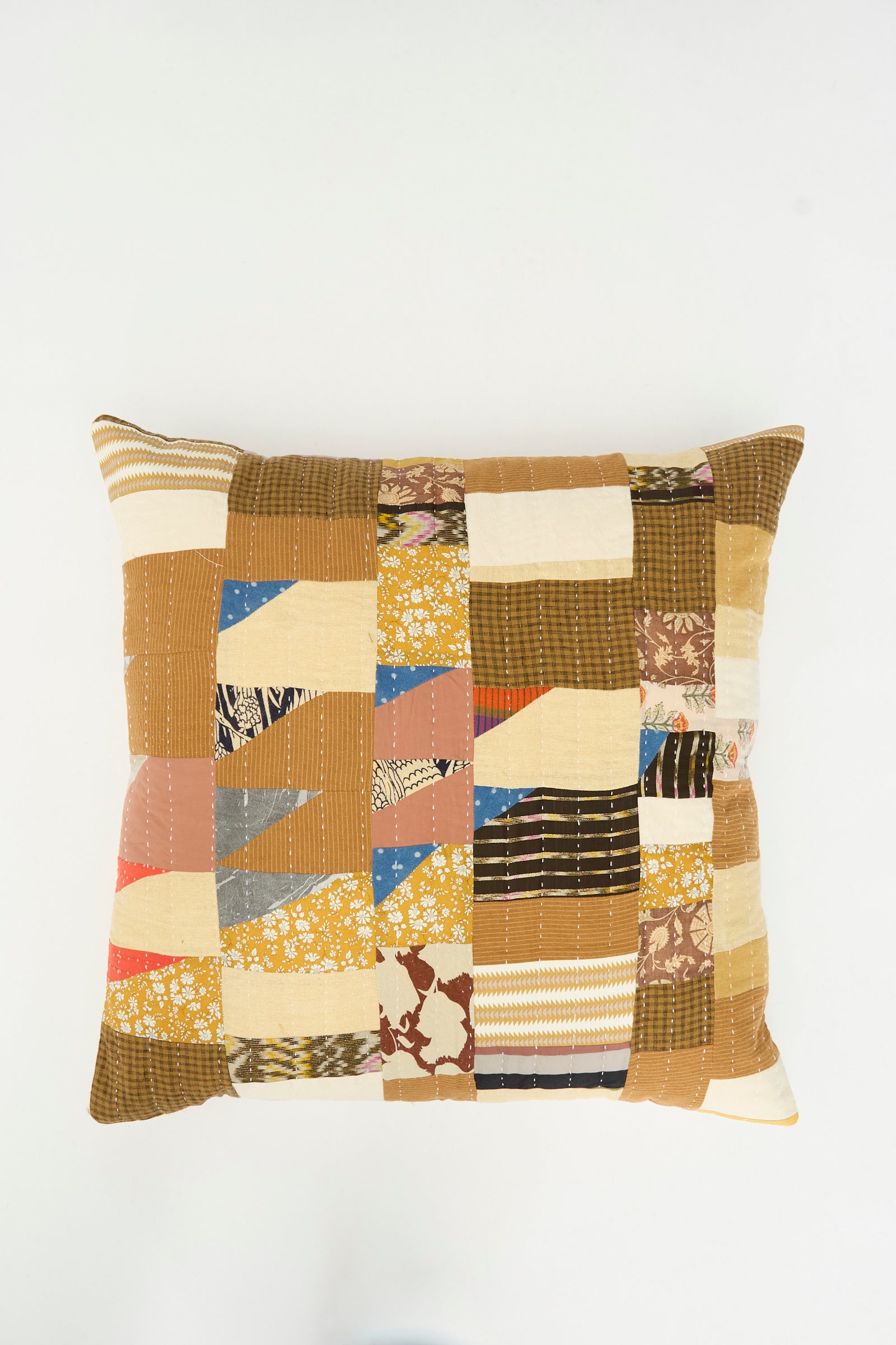 The Counterpane Patchwork Pillow in Yellow Gold Multi II features a square patchwork design with assorted brown, beige, yellow, and patterned fabric pieces—crafted from antique found cloth and photographed on a plain white background. This unique pillow is made in California.