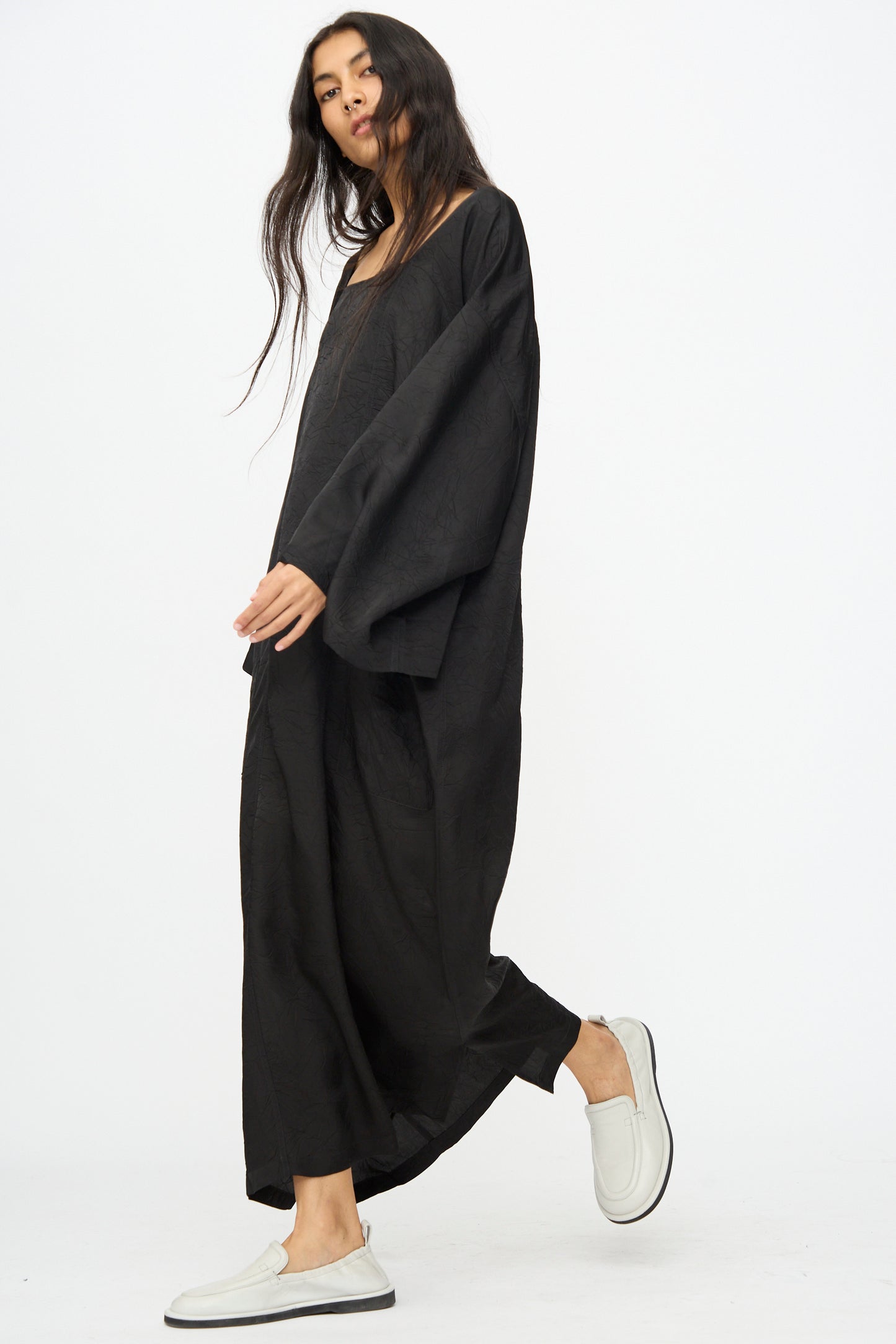 A woman wearing the Cristaseya Square Neck Caftan Dress in Black and white slip-on shoes stands against a plain white background.
