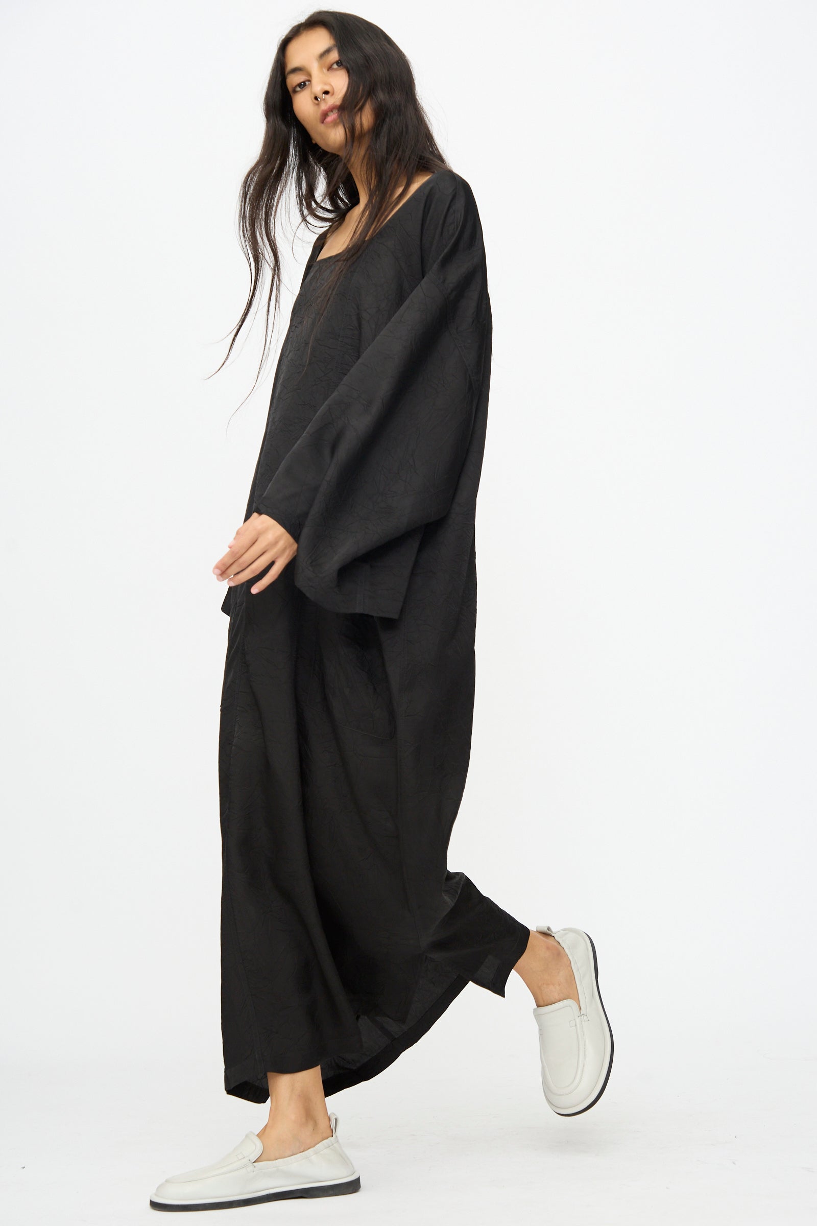 A woman wearing the Cristaseya Square Neck Caftan Dress in Black and white slip-on shoes stands against a plain white background.
