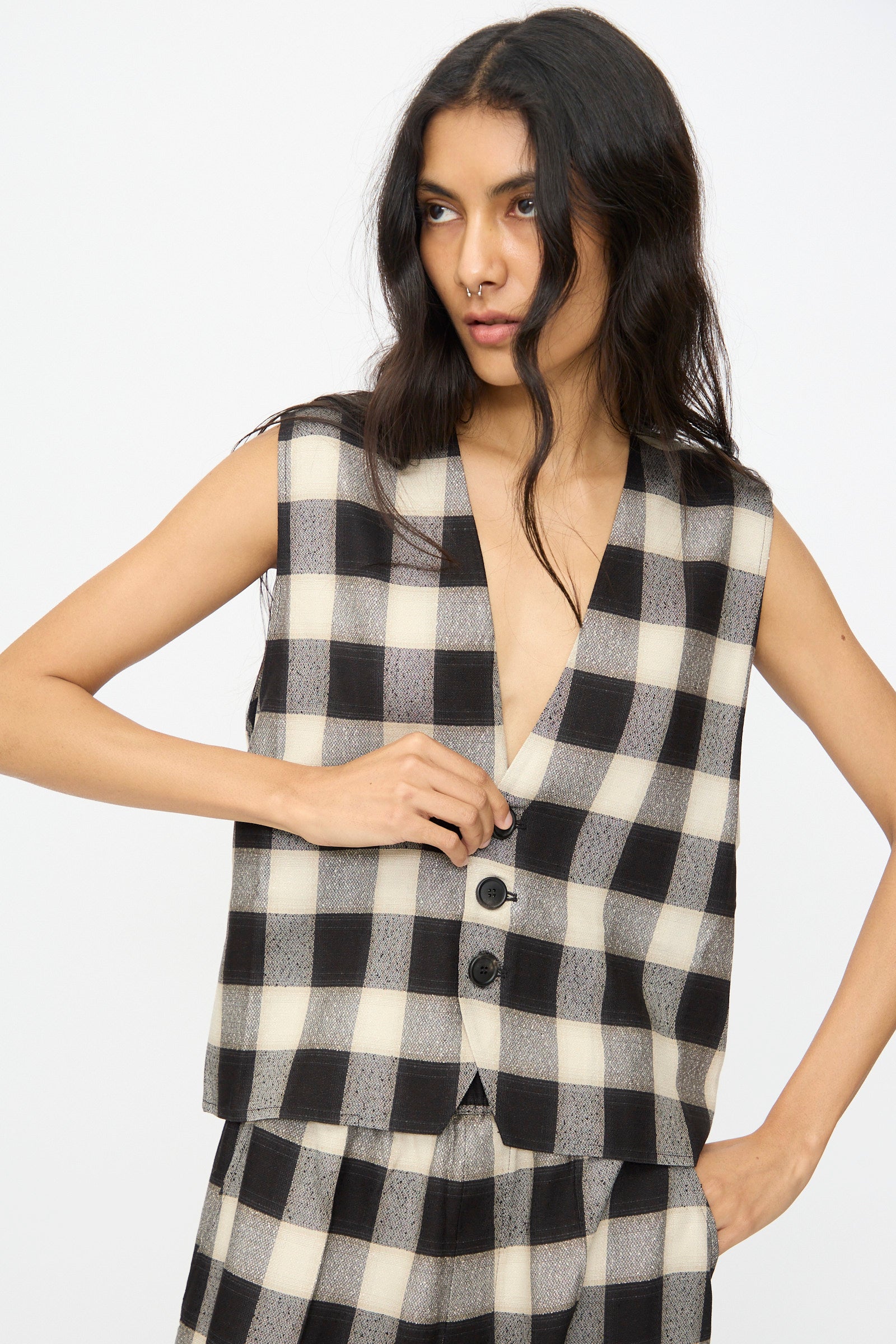 A woman wears the Cristaseya Button Down Vest in Black and Cream Checks with matching pants, standing against a plain white background.