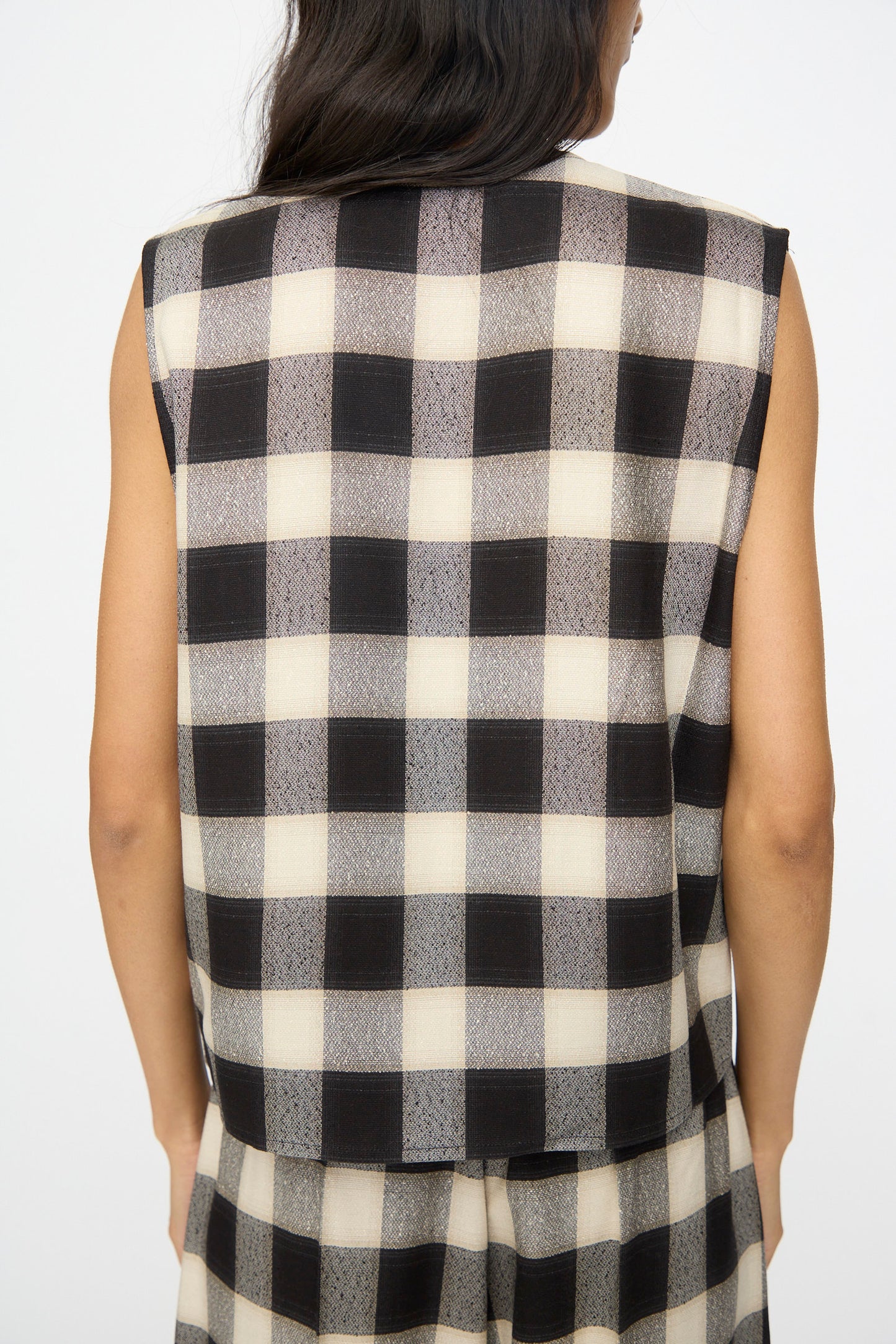 A person is seen from the back wearing Cristaseya's Button Down Vest in Black and Cream Checks with matching pants.