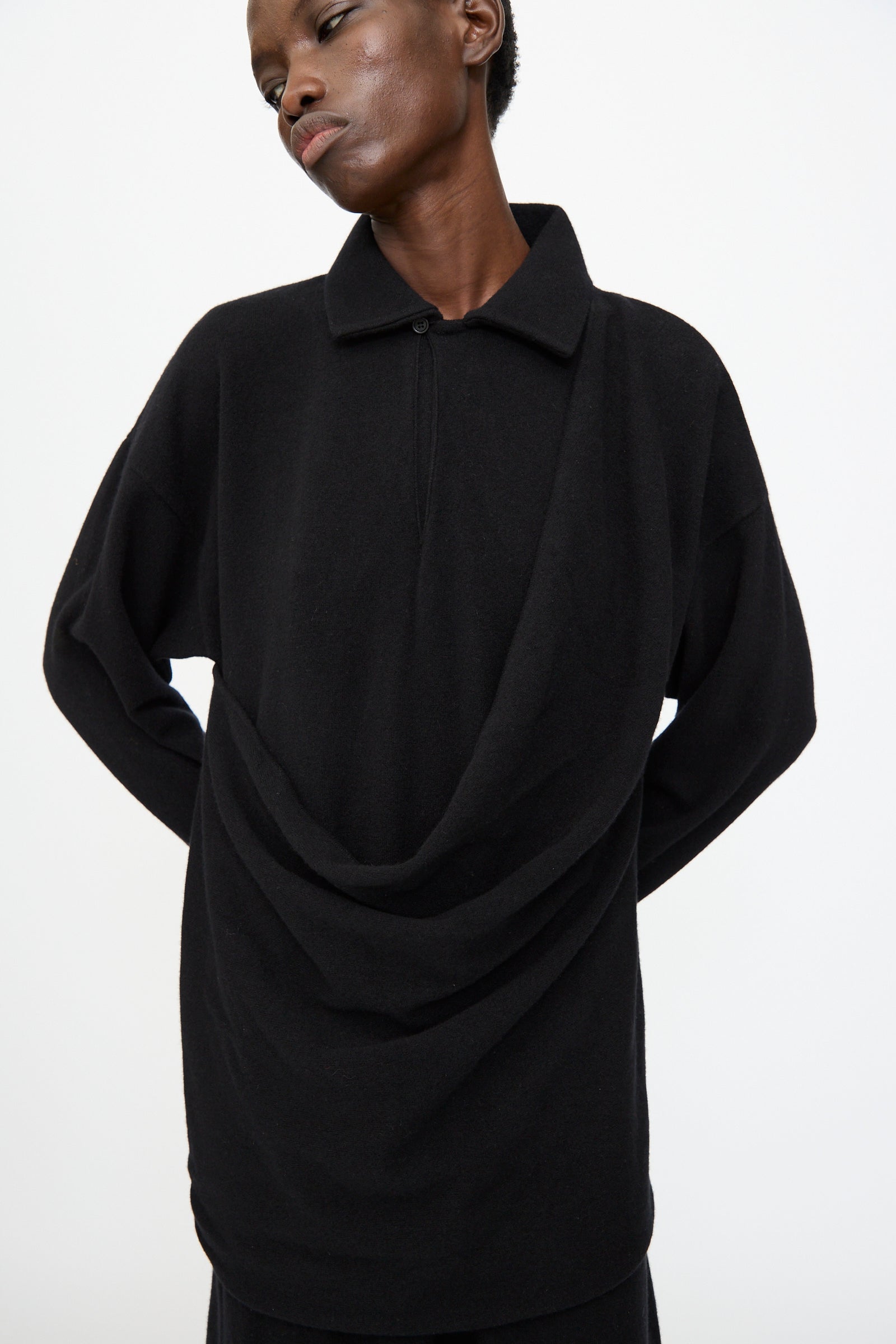 A person wears the Cristaseya Flannel Polo Dress in Black, a loose-fitting, long-sleeve collared maxi dress, standing against a plain white background.