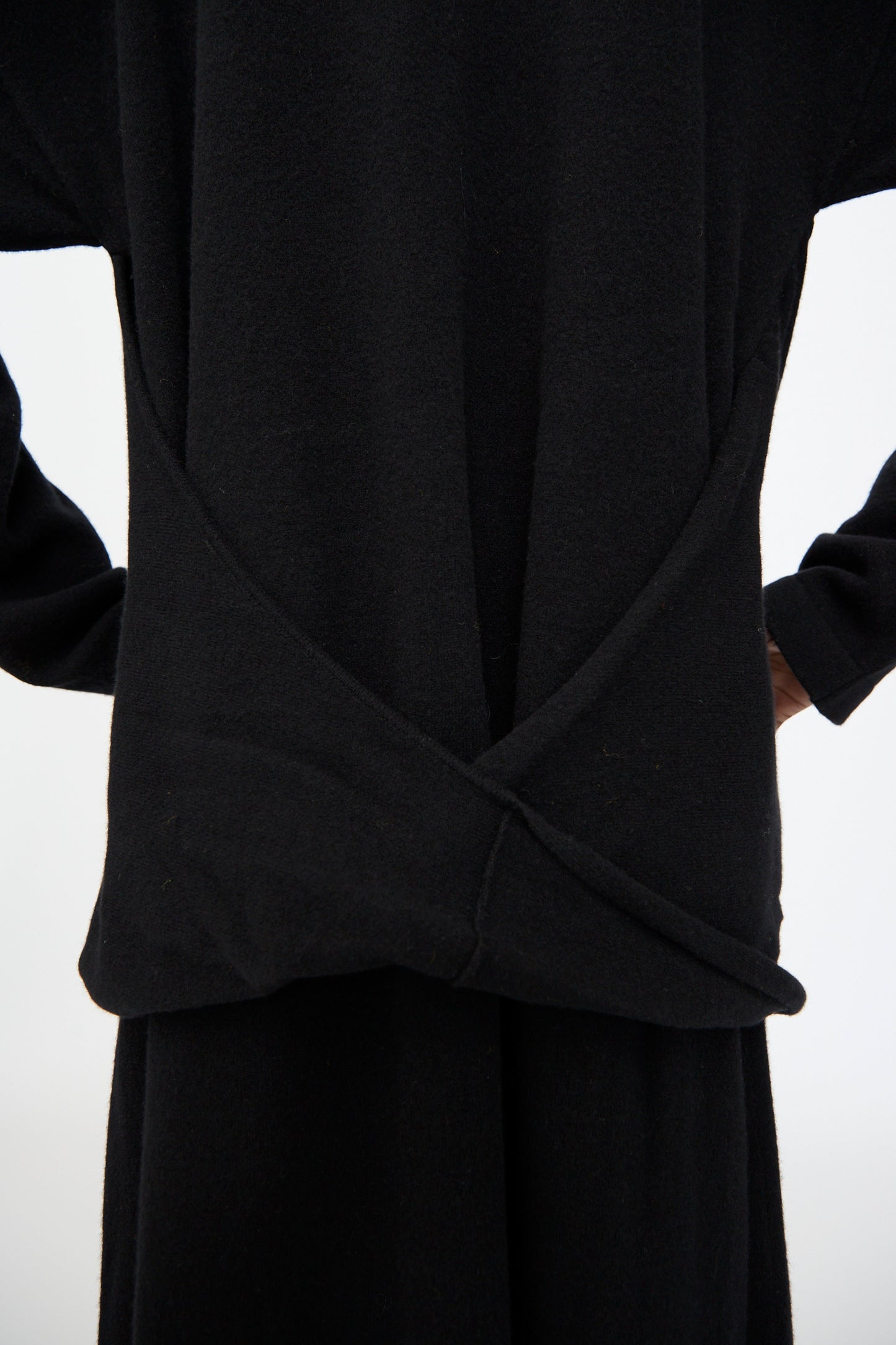 A person wearing the Cristaseya Flannel Polo Dress in Black, featuring long sleeves and an overlapping back detail, stands against a plain white background.