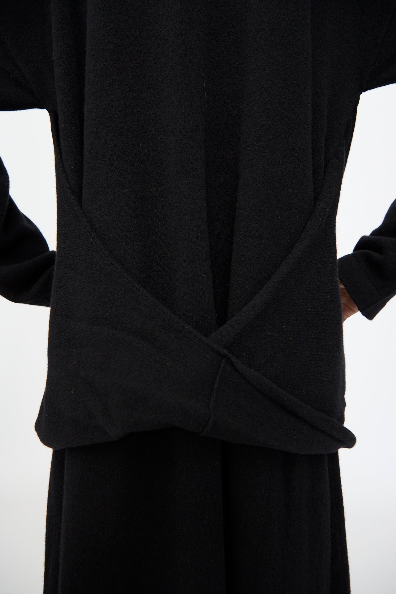 A person wearing the Cristaseya Flannel Polo Dress in Black, featuring long sleeves and an overlapping back detail, stands against a plain white background.