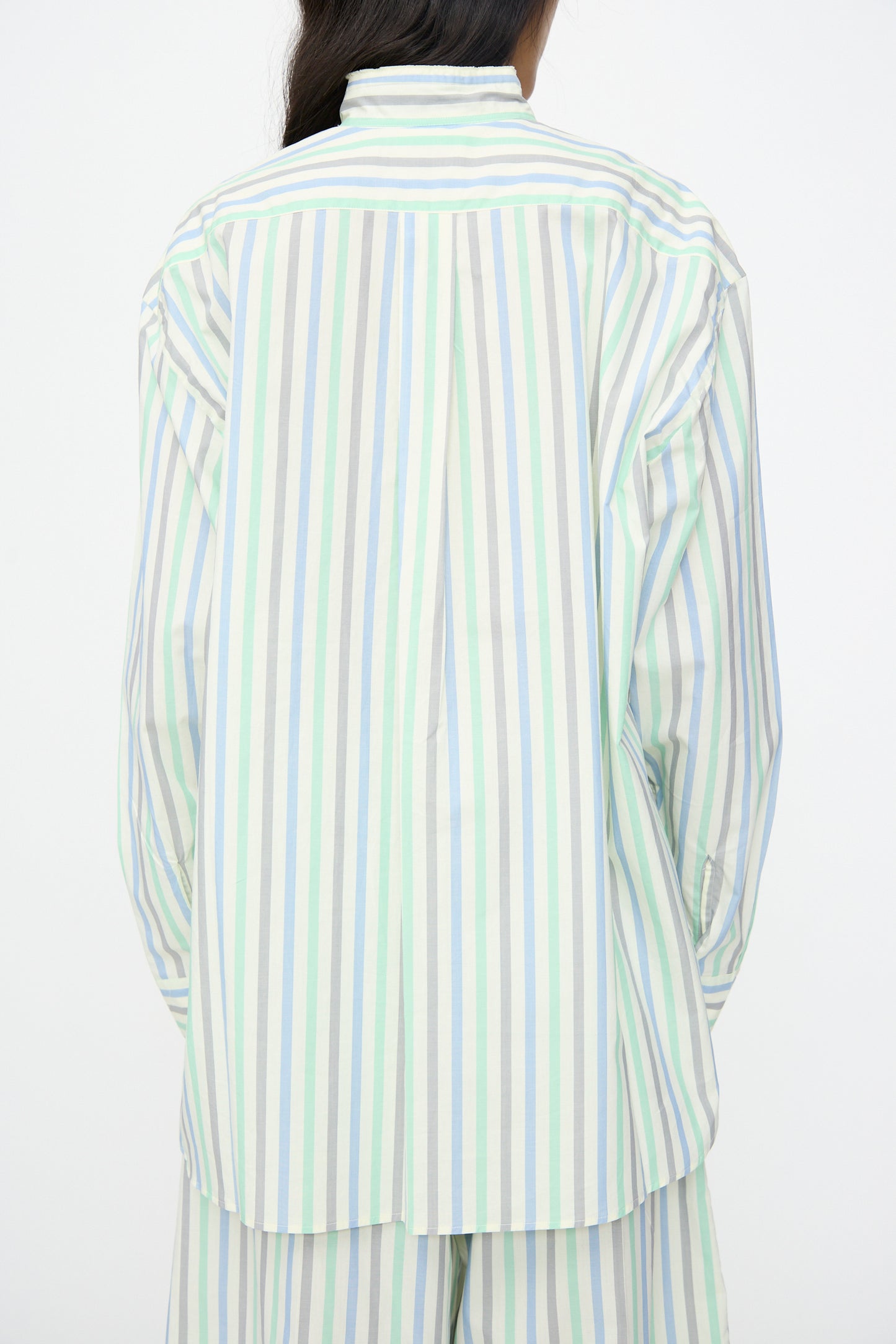 A person wears the Cristaseya Handmade Fringed Mao Collar Shirt in Striped Pastel Green, shown from the back against a plain white background.