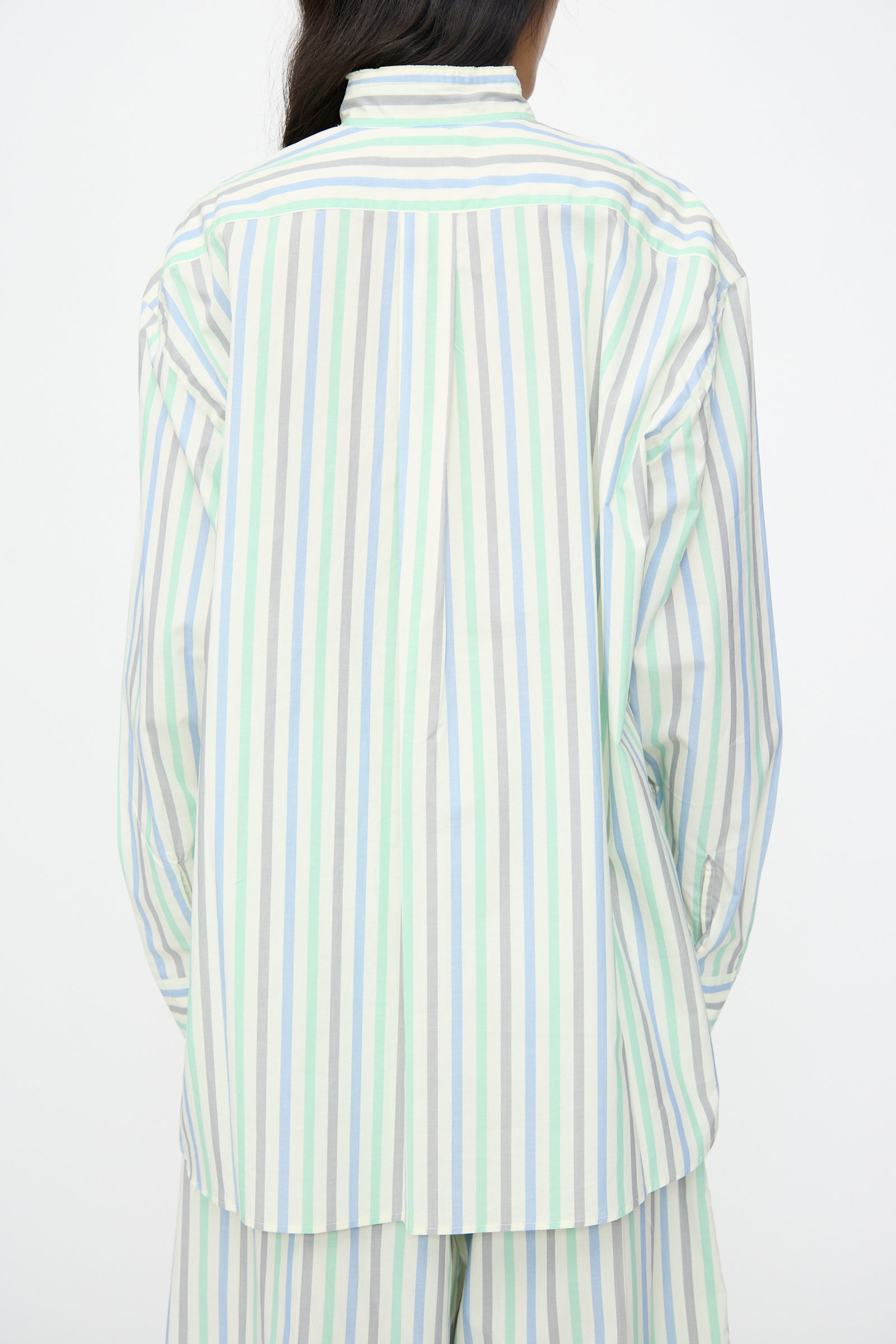 A person wears the Cristaseya Handmade Fringed Mao Collar Shirt in Striped Pastel Green, shown from the back against a plain white background.