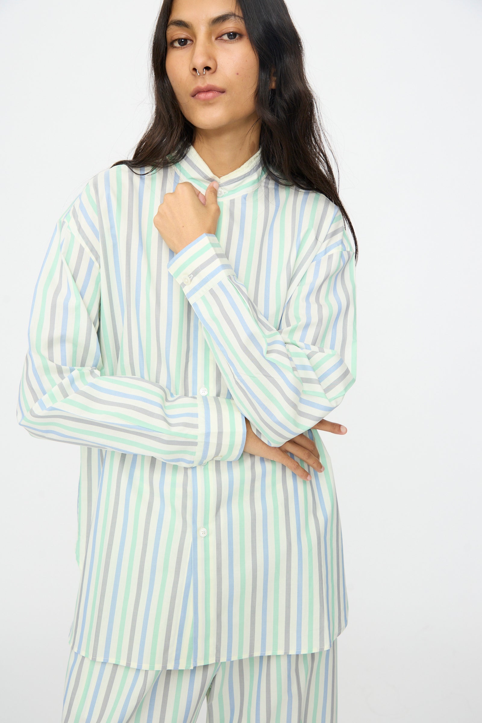 A person with long dark hair models the Cristaseya Handmade Fringed Mao Collar Shirt in Striped Pastel Green against a plain white background.