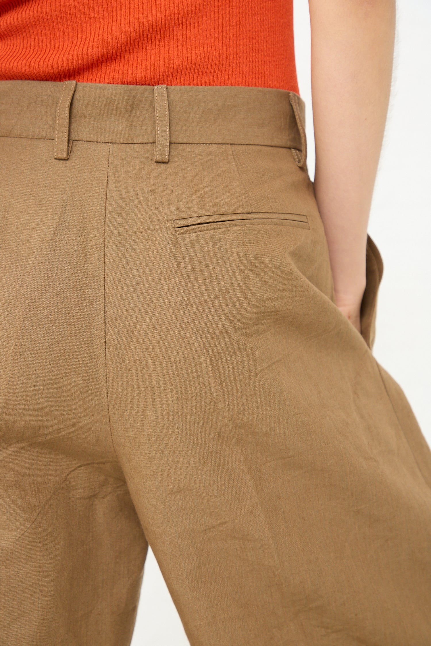 The back view of a woman wearing Cristaseya's Japanese Washi and Linen Canvas Double Pleated Wide Trouser in Mocha. Up close view.