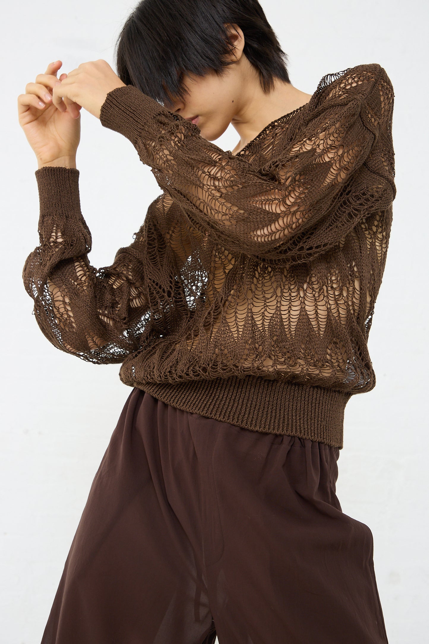 A woman wearing a Cristaseya Linen Lace Sweater in Brown. Front view.