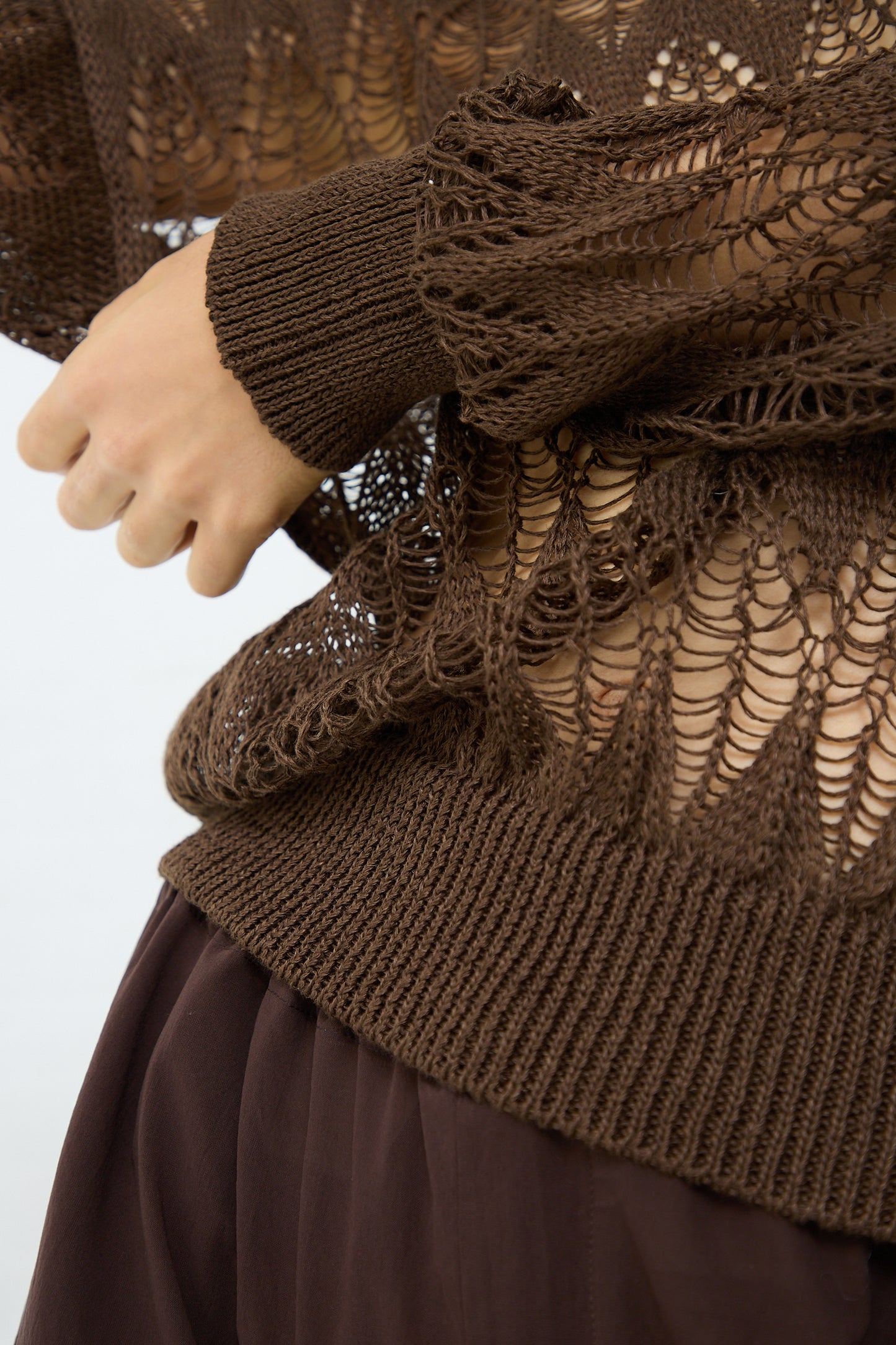 The front of a woman wearing a Cristaseya Linen Lace Sweater in Brown made of 100% linen. Up close.
