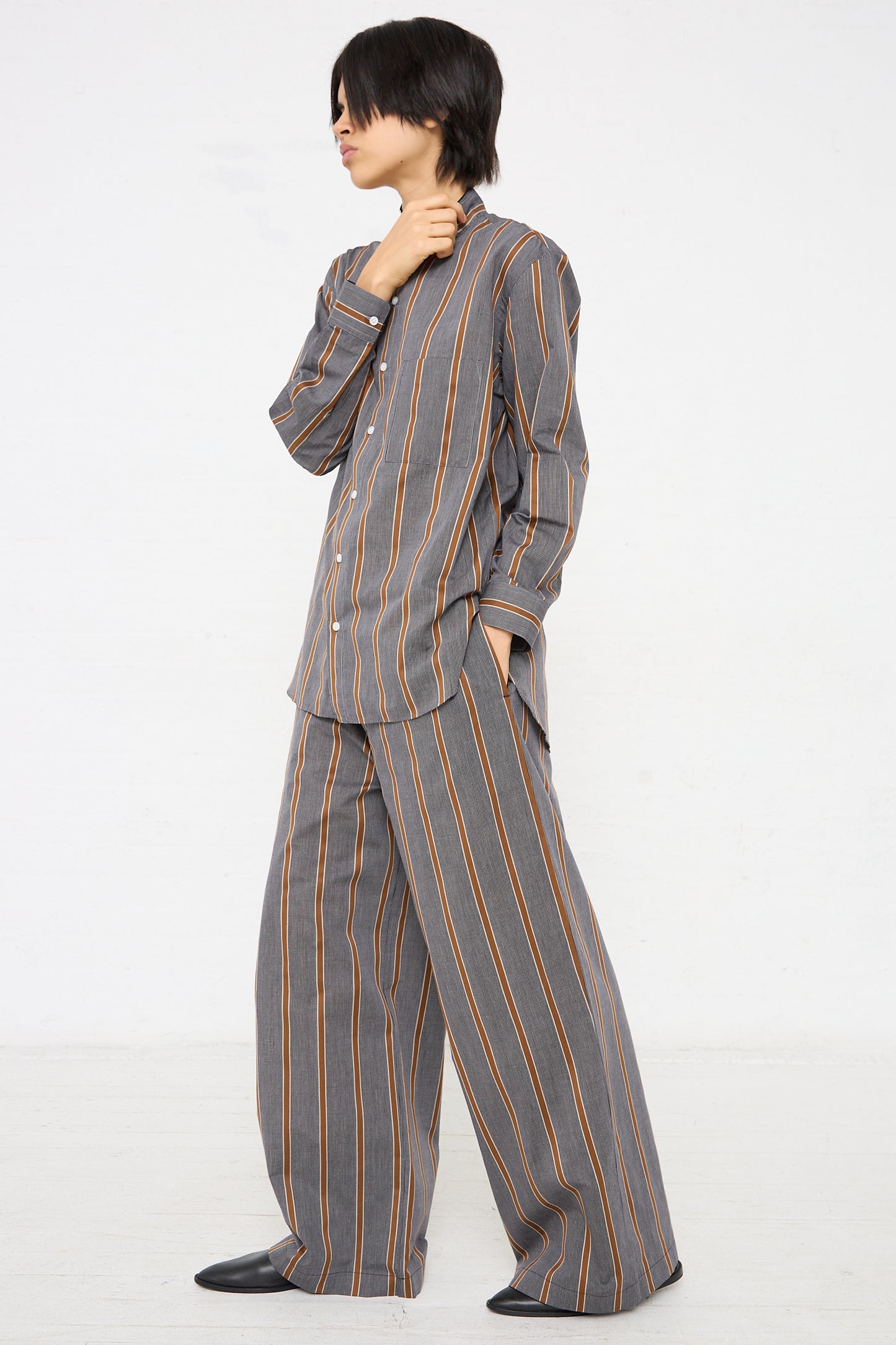 The model is wearing a Cristaseya Maxi Large Pant in Striped Black and Noisette pajama set with wide leg and oversized drawstring pants.
