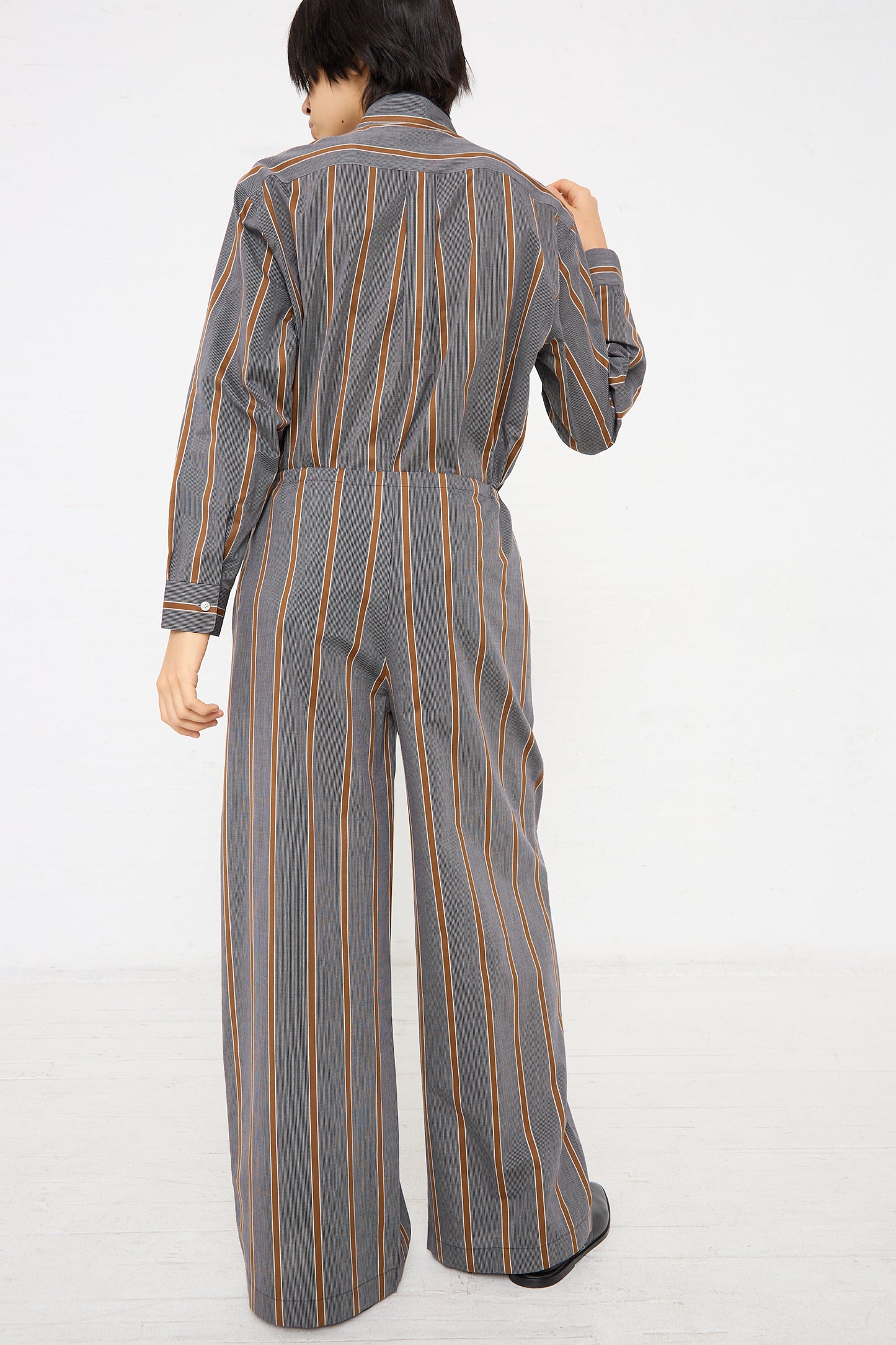 The back view of a woman in an oversized drawstring Maxi Large Pant jumpsuit made of lightweight Japanese cotton by Cristaseya.