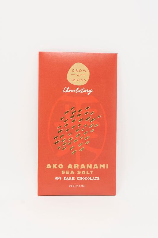 A red Crow & Moss wrapper displays "Ako Aranami Sea Salt Dark Chocolate" with a subtle abstract pattern.
