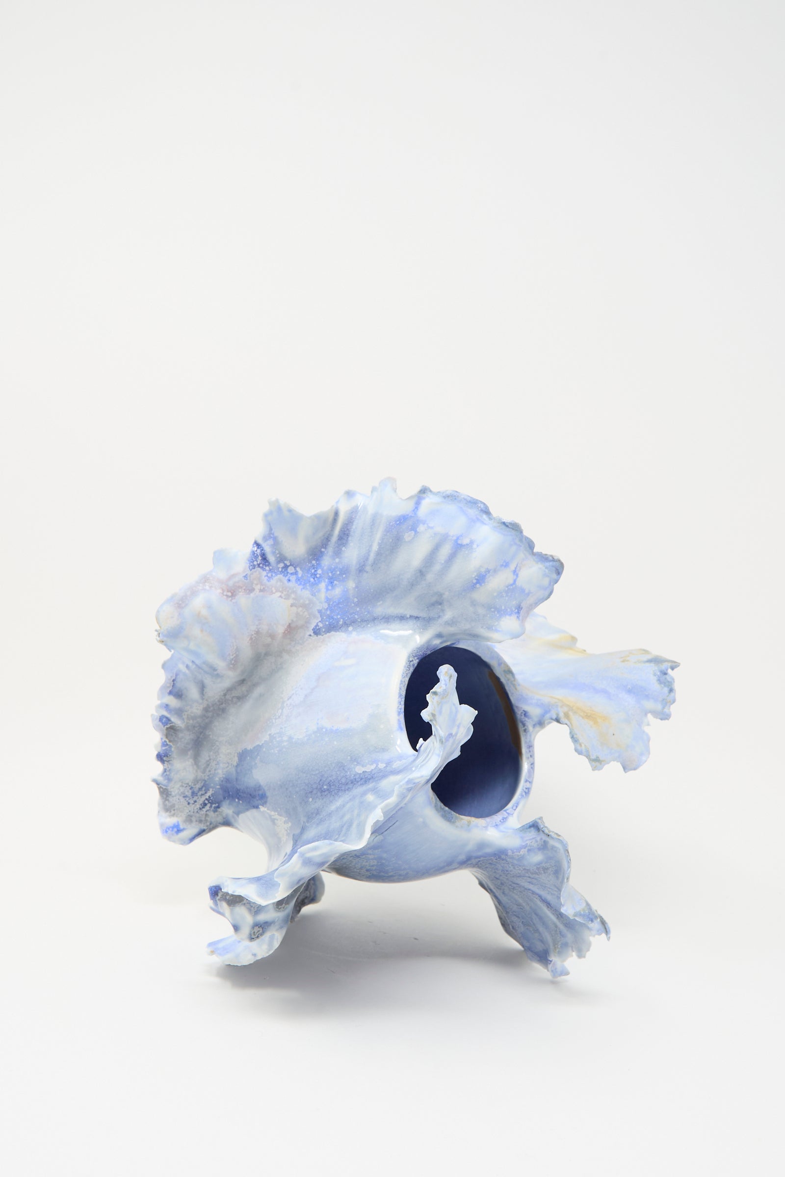 The Dear You Ash Bloom N.8 Woodfired in Blue is a handmade porcelain vase with ruffled, wavy edges and a blue, white, and purple marbled glaze, shown on its side against a plain white background.