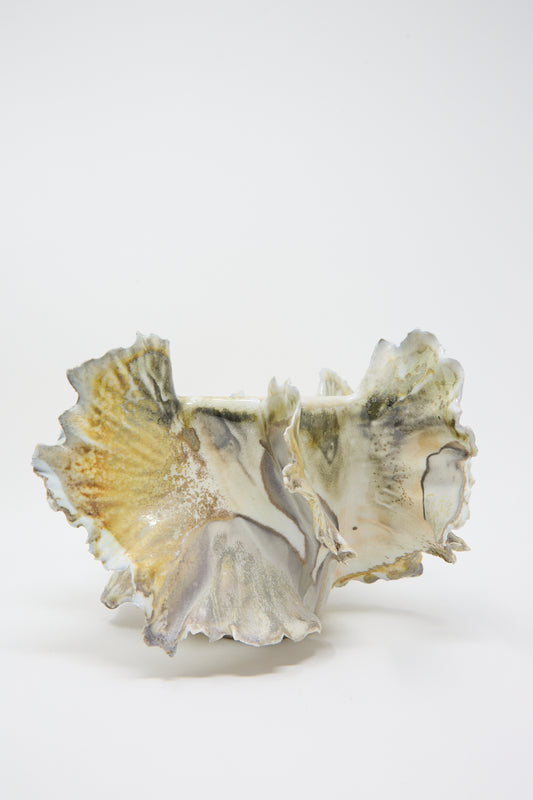 A unique, hand-built ceramic sculpture with ruffled edges and a marbled texture in shades of gray, white, and yellow, set against a plain white background. Crafted from high-quality porcelain, the Ash Bloom N11 Vase by Dear You stands out as an elegant addition to any space.