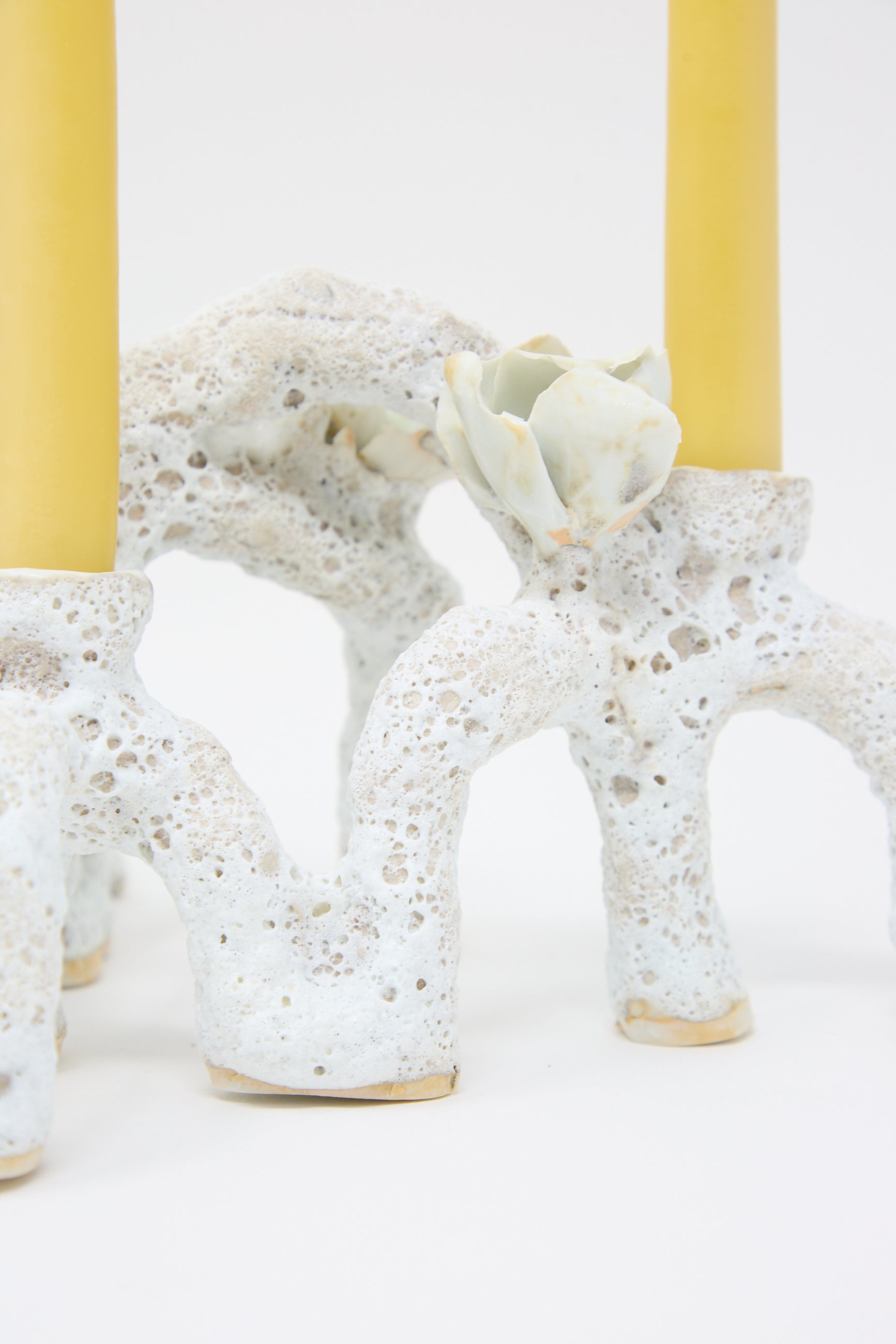 Close-up of a Dear You Blooming Arches Candle Holder with a coral-like design and two yellow candles, featuring luminescent petals in the form of small decorative flower details.