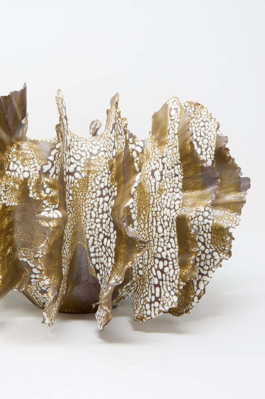 The Wild Petal N. 10 by Dear You is an abstract ceramic sculpture with textured gold and white patterns against a neutral background.