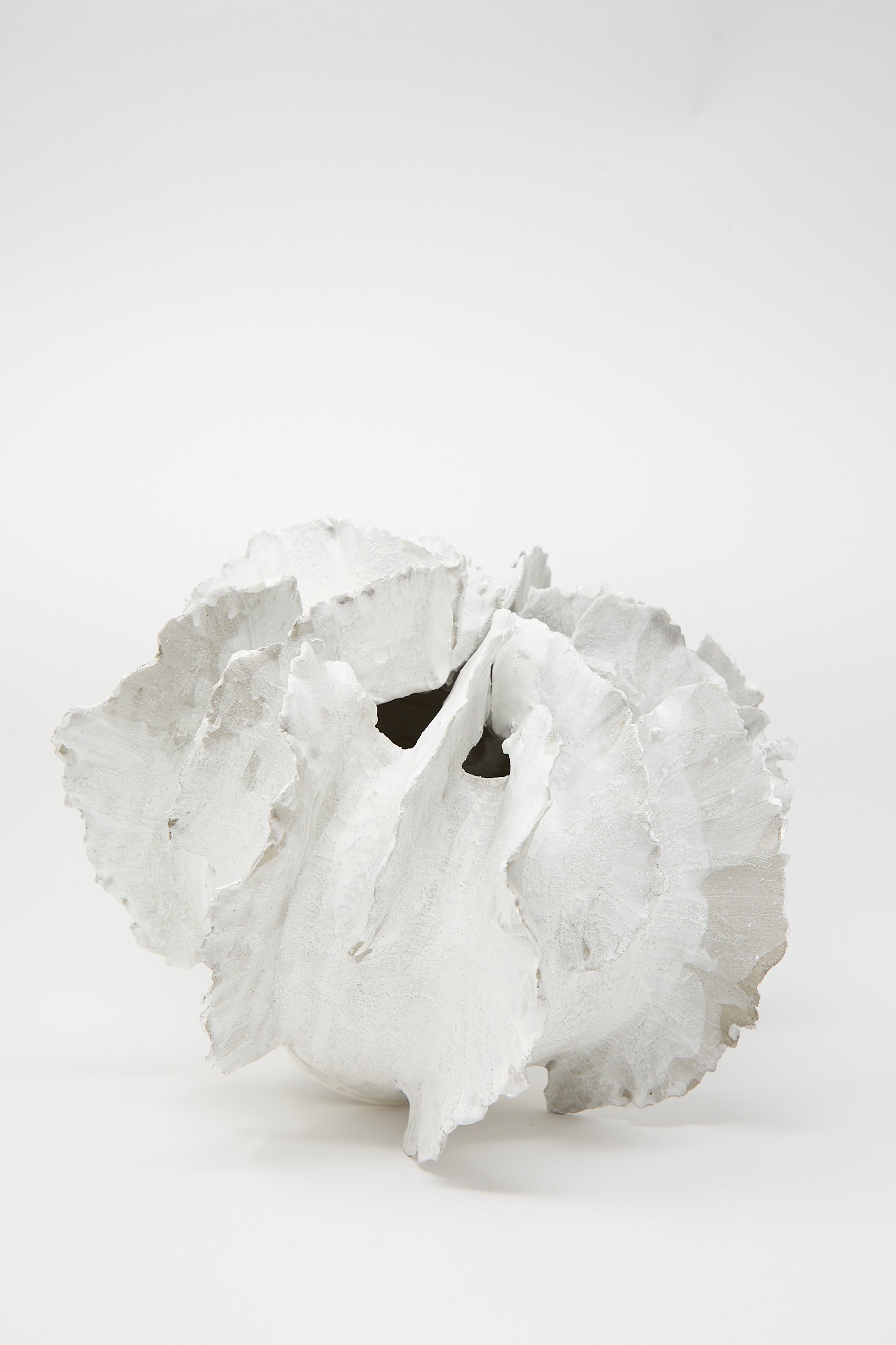 The Wild Petals N. 11 Vase by Dear You is a hand-built abstract sculpture crafted from white ceramic, featuring irregular petal-like forms and textured surfaces, set against a plain background.