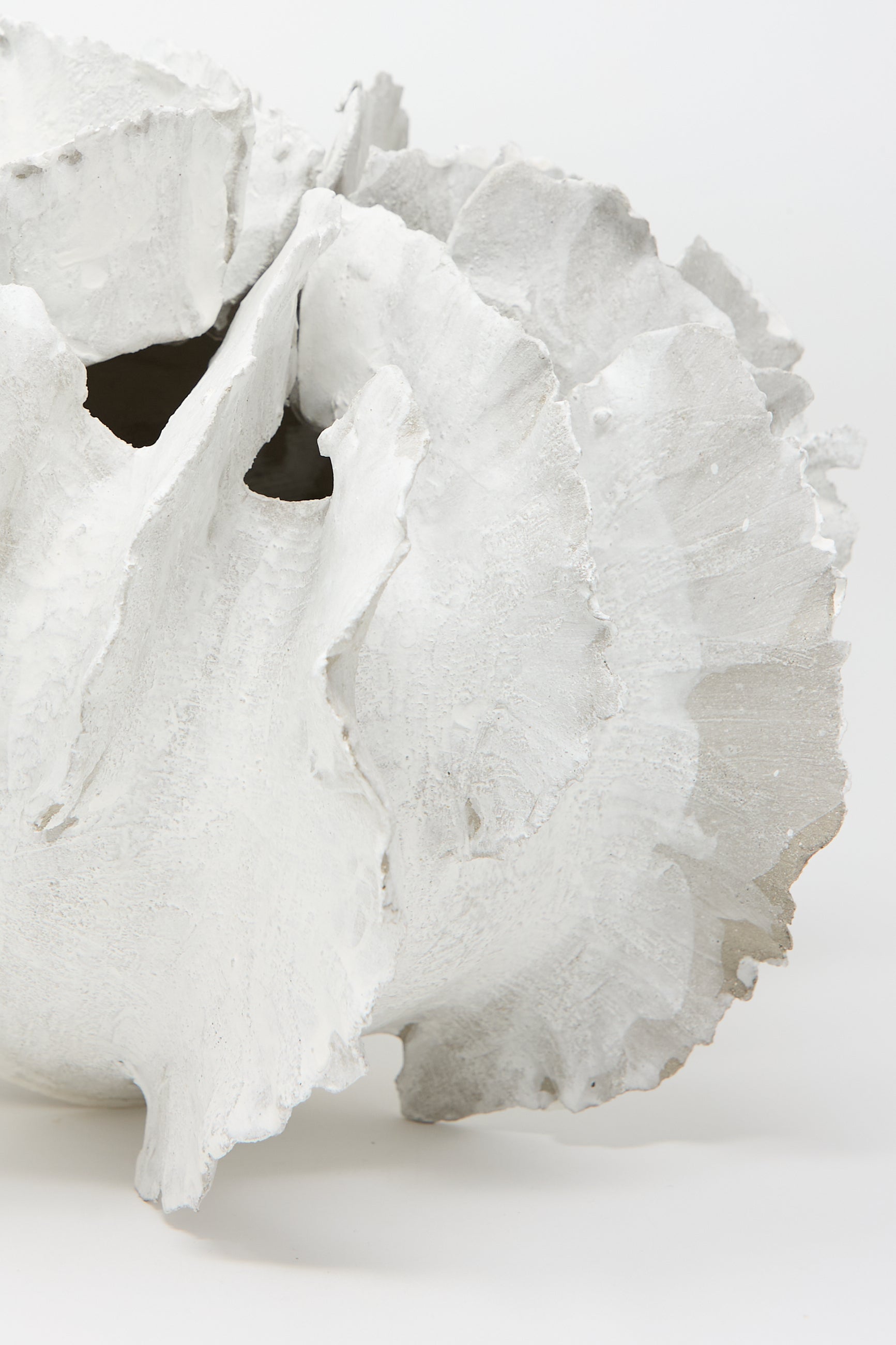 A detailed close-up of the Wild Petals N. 11 Vase by Dear You, showcasing its textured, hand-built ceramic form with layered wavy edges and open spaces, finished in a Terra Sigilata Glaze and displayed against a plain background.