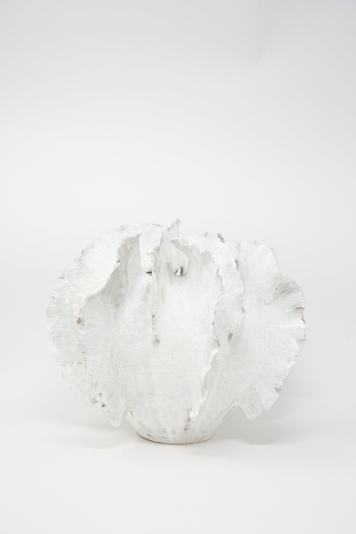 The Wild Petals N. 11 Vase by Dear You is a hand-crafted, white ceramic piece designed to resemble abstract coral, featuring a textured surface accentuated by a Terra Sigilata glaze, all set against a simple white backdrop.