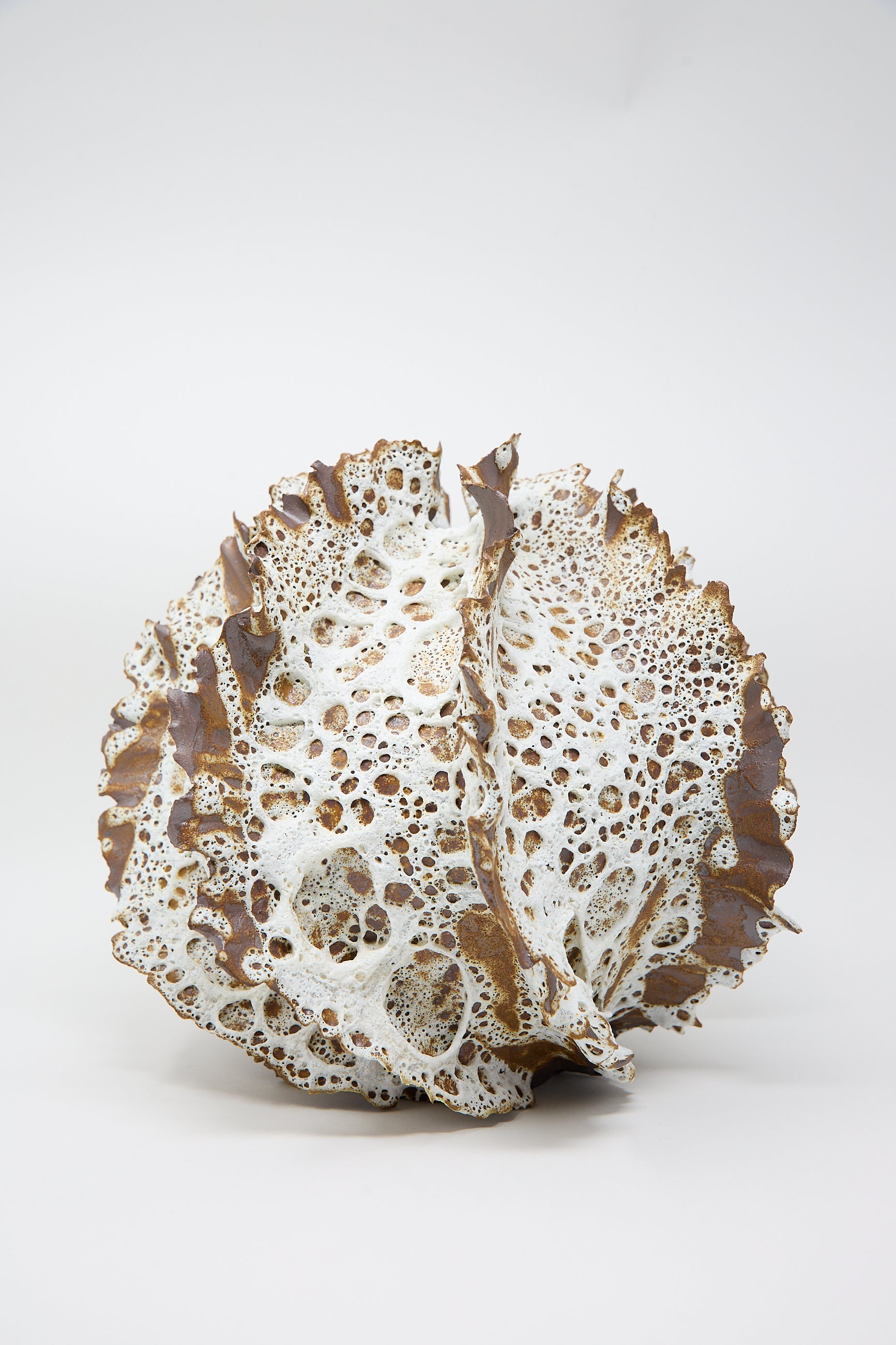 The Wild Petals N. 13 Vase by Dear You is showcased against a plain background, exhibiting a hand-built spherical design with brown and white porous surfaces that resemble coral, highlighted by its distinct textured glaze finish.