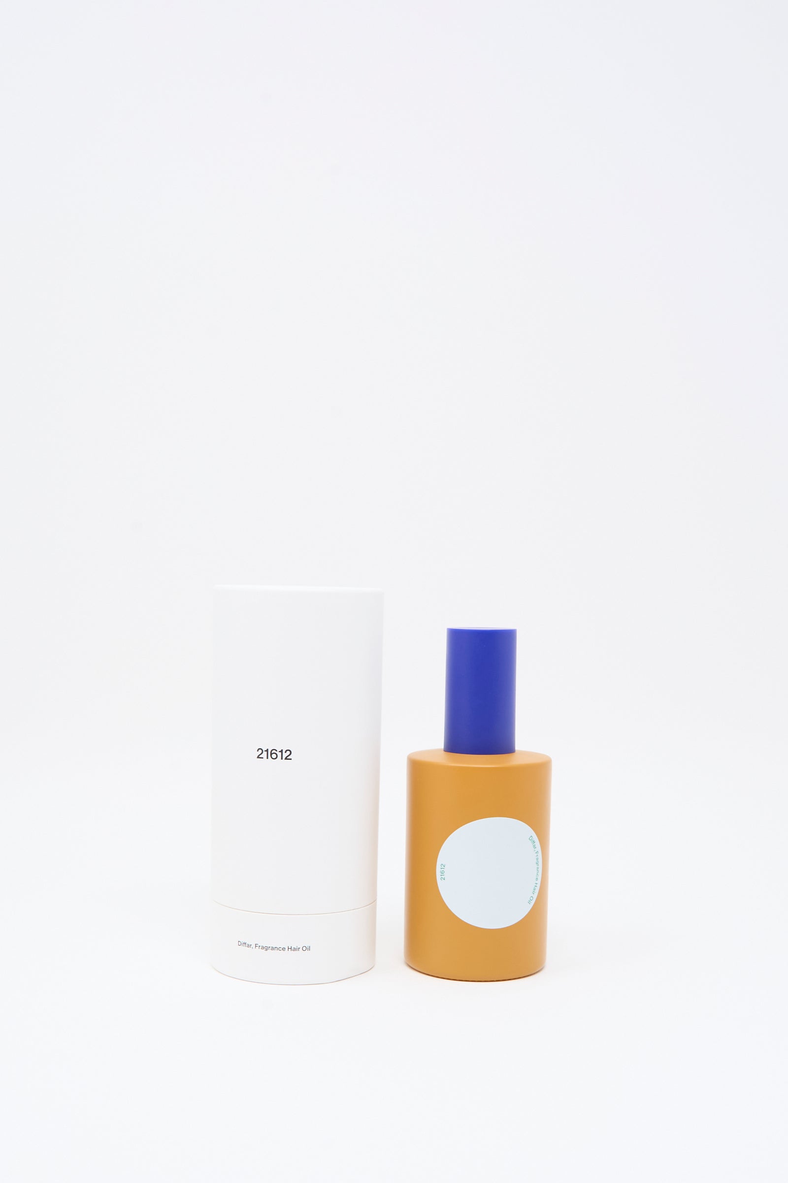 A white cylindrical container labeled "21612" stands next to a yellow bottle with a blue cap and a blank light blue label—identified as Diffar's Woody Earthy Fragrance Oil—both set against a clean white background.