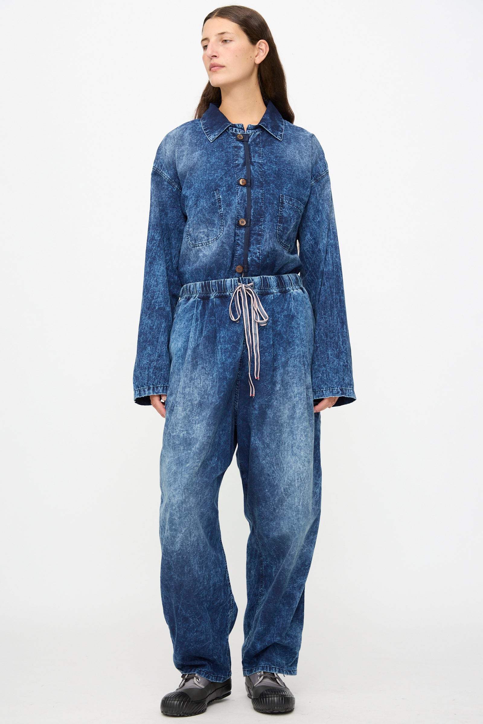 A person wearing Dr. Collectors’ 6 oz. Cotton P43 Kyoto Pant in Sunfaded Indigo, paired with black shoes and standing against a plain white background.