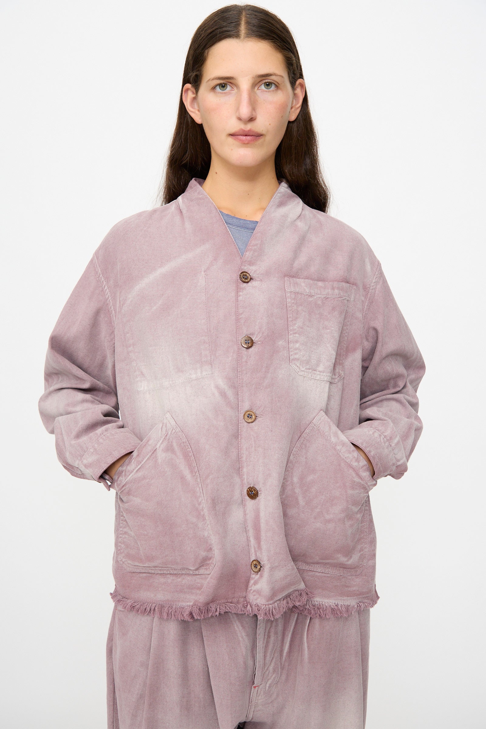 A person wearing the Dr. Collectors 9 oz. Okinawa Jacket in Sunfaded Dusty Orchid, crafted from a linen cotton blend with pockets and matching pants, stands against a plain white background.