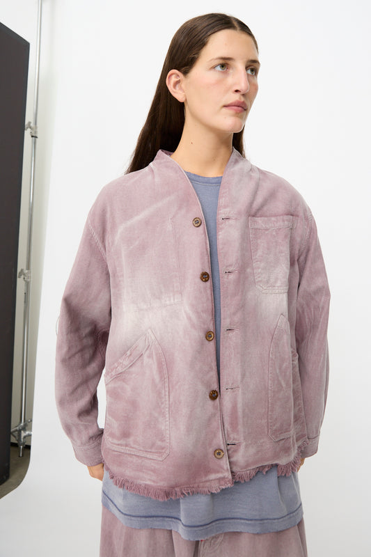 A person wearing the Dr. Collectors 9 oz. Okinawa Jacket in Sunfaded Dusty Orchid—a light purple linen-cotton blend button-up with large pockets—over a blue shirt, standing against a plain background.