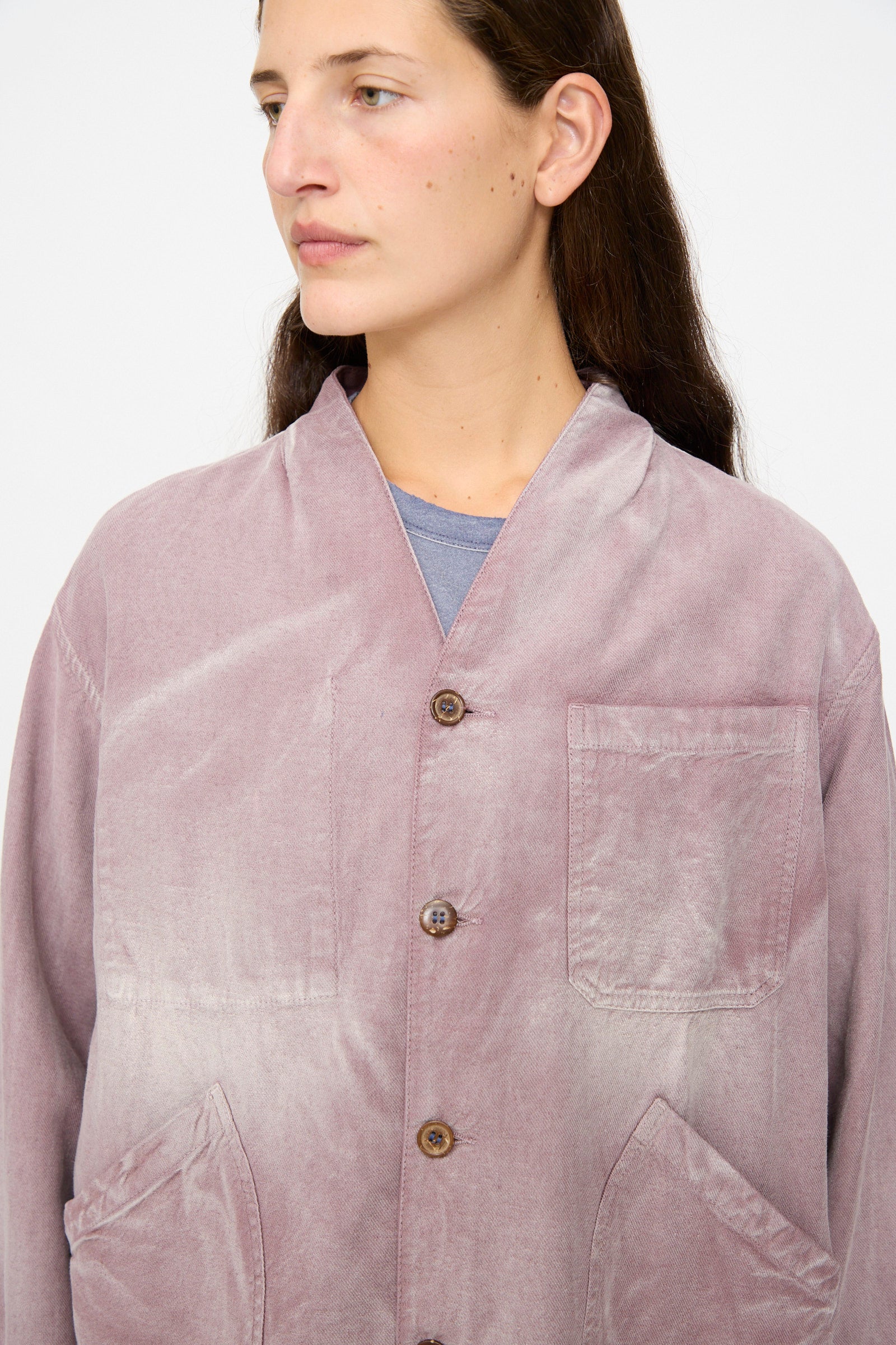 A person wearing the Dr. Collectors 9 oz. Okinawa Jacket in Sunfaded Dusty Orchid, featuring three front pockets and crafted from a soft linen-cotton blend, stands against a plain light background.