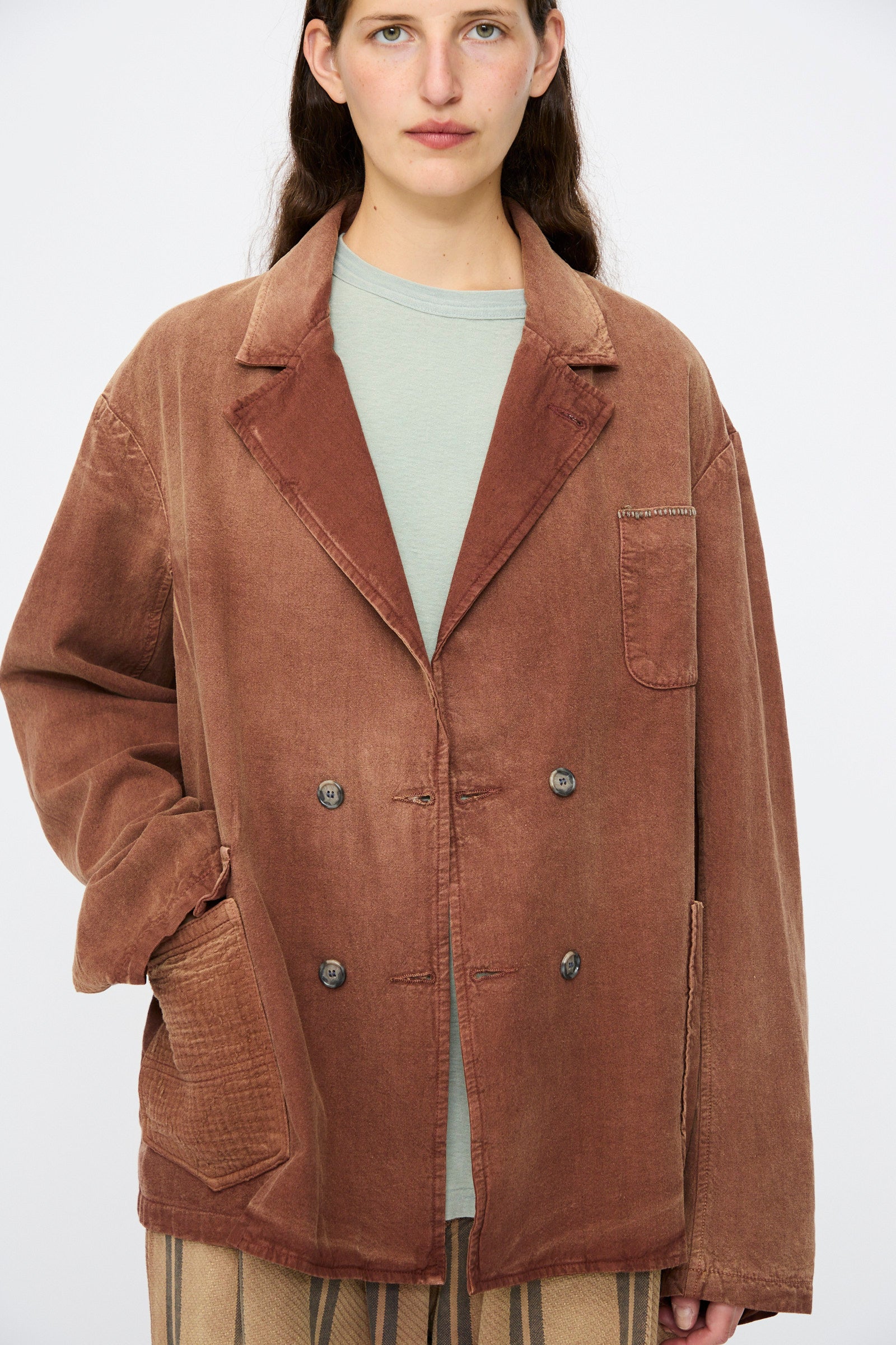 A person wearing the Dr. Collectors Bogart Jacket in Nuts, a vintage-style brown oversized double-breasted blazer in a linen-cotton blend, layered over a light green shirt and standing against a plain background.