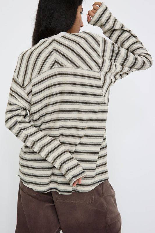 A person wearing the Hemp and Cotton Derrick Tee Stripes in Sunfaded Stone by Dr. Collectors, along with brown pants, is facing away against a white background. 