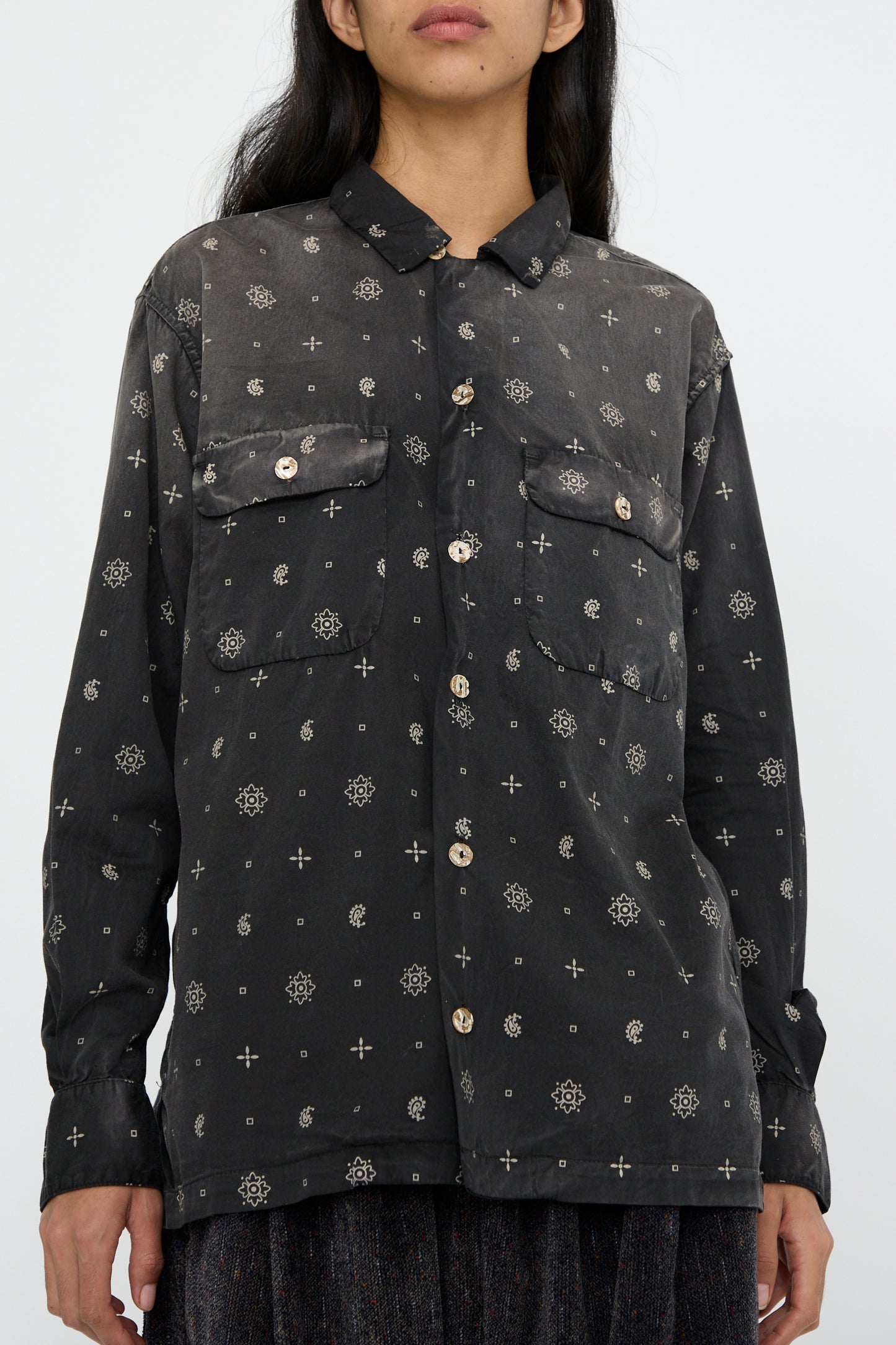 A person stands against a plain background, wearing the "Sateen Cotton Bowling Long Sleeve in Smoke Black" by Dr. Collectors, seen from below the chin. 