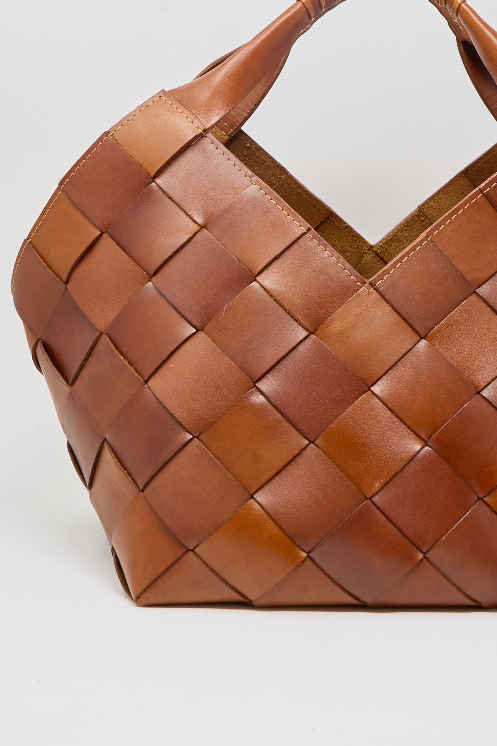 A close-up of the Dragon Diffusion Botteghe Bag in Tan, featuring woven brown leather, a V-shaped opening, and braided handles, set against a plain white background.