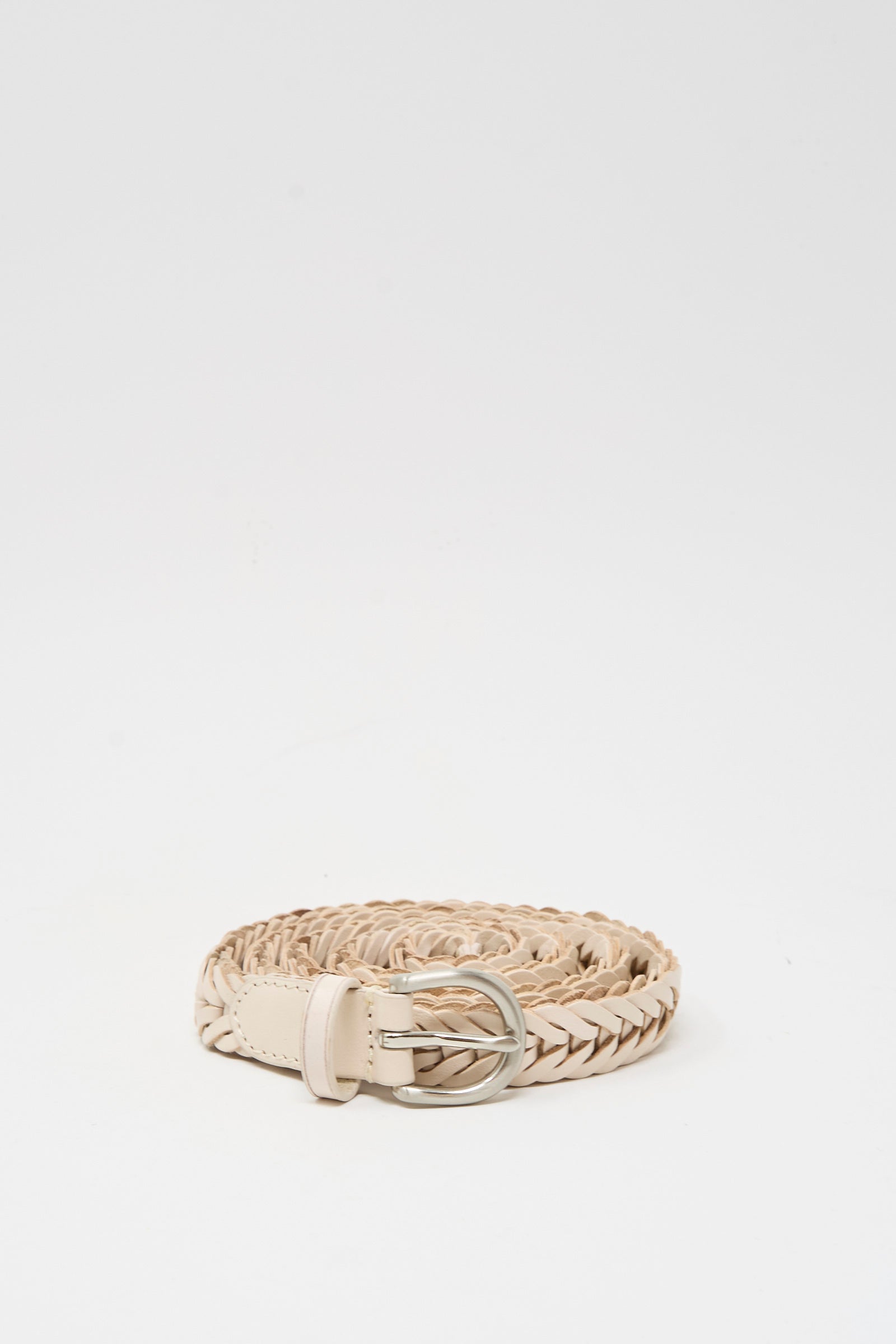 The Dragon Diffusion Brass Buckle Single Link Belt in Sand, a handcrafted braided leather belt with a brass buckle, is coiled neatly on a plain white background.
