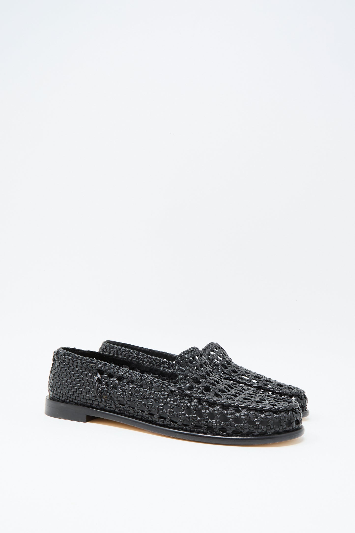 The Dragon Diffusion Dolly Moccasin in Black features woven leather and flat soles, showcased against a plain white background.